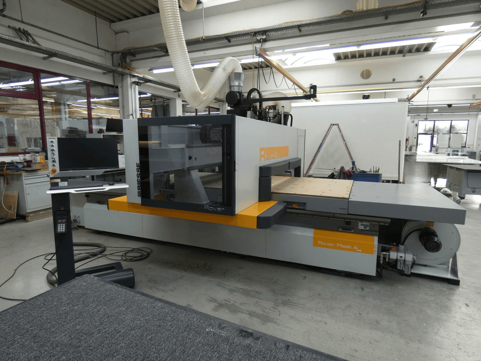 Framifrånvy av CNC-bearbetningscentret BIESSE ROVER PLAST A FT 1224 för träbearbetning, där skärmen och kontrollpanelen syns.