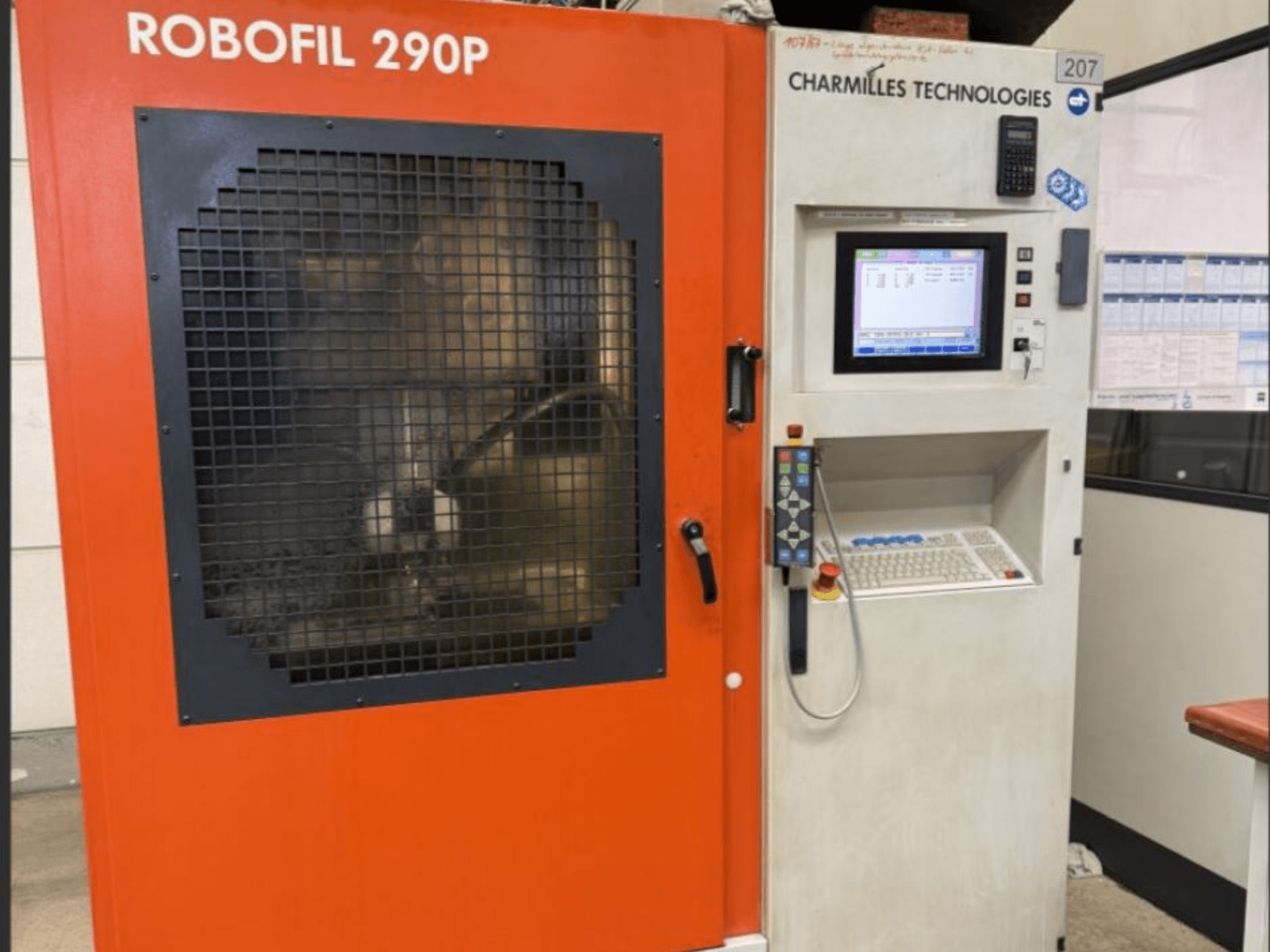 Frontvy av CHARMILLES TECHNOLOGIES Robofil 290P trådgnistmaskin med kontrollpanel och gallerförsett arbetsområde.