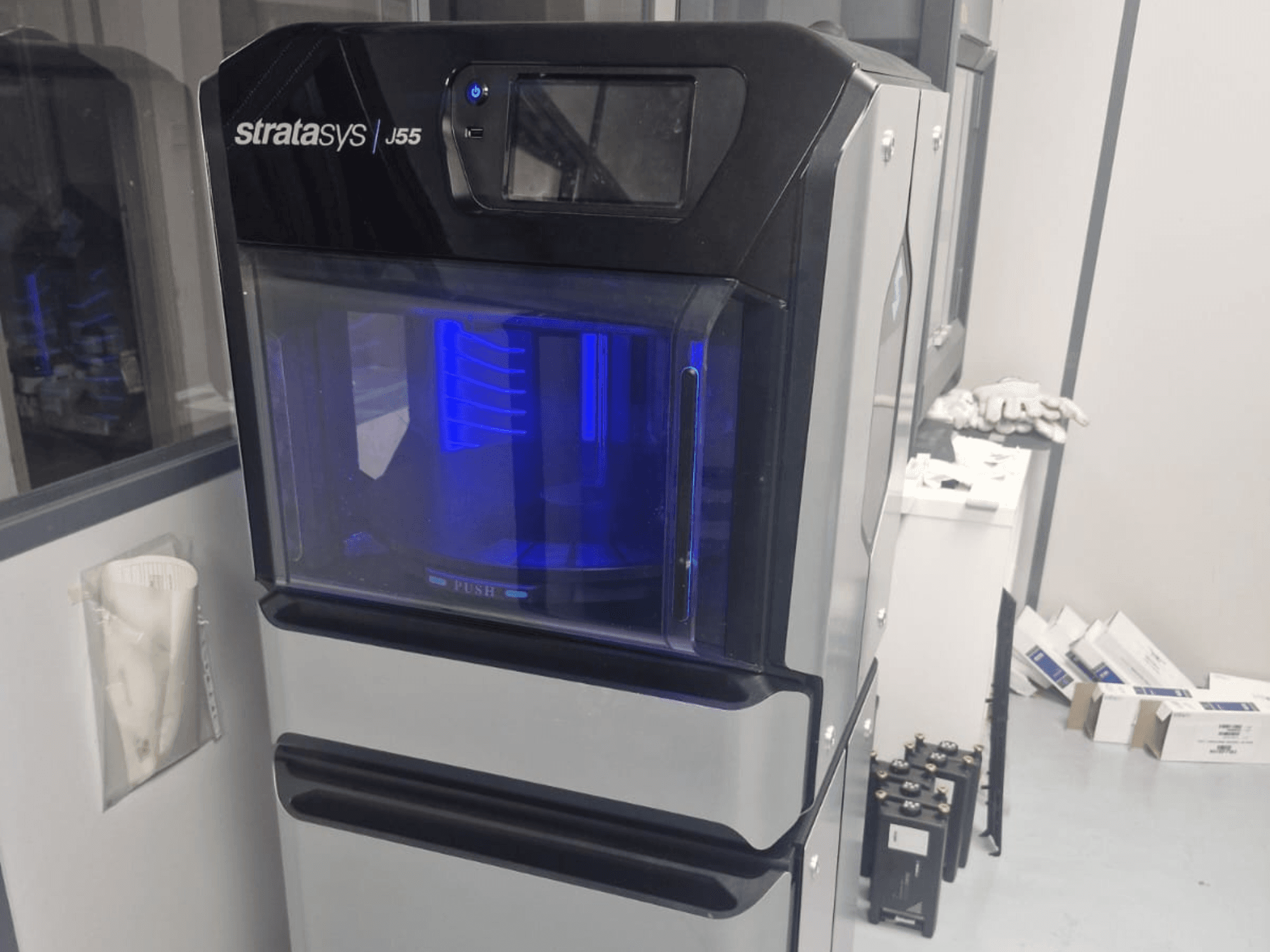 Stratasys J55 Prime 3D-skrivare för plast i sidovy, som visar den eleganta designen och det upplysta utskriftsområdet.