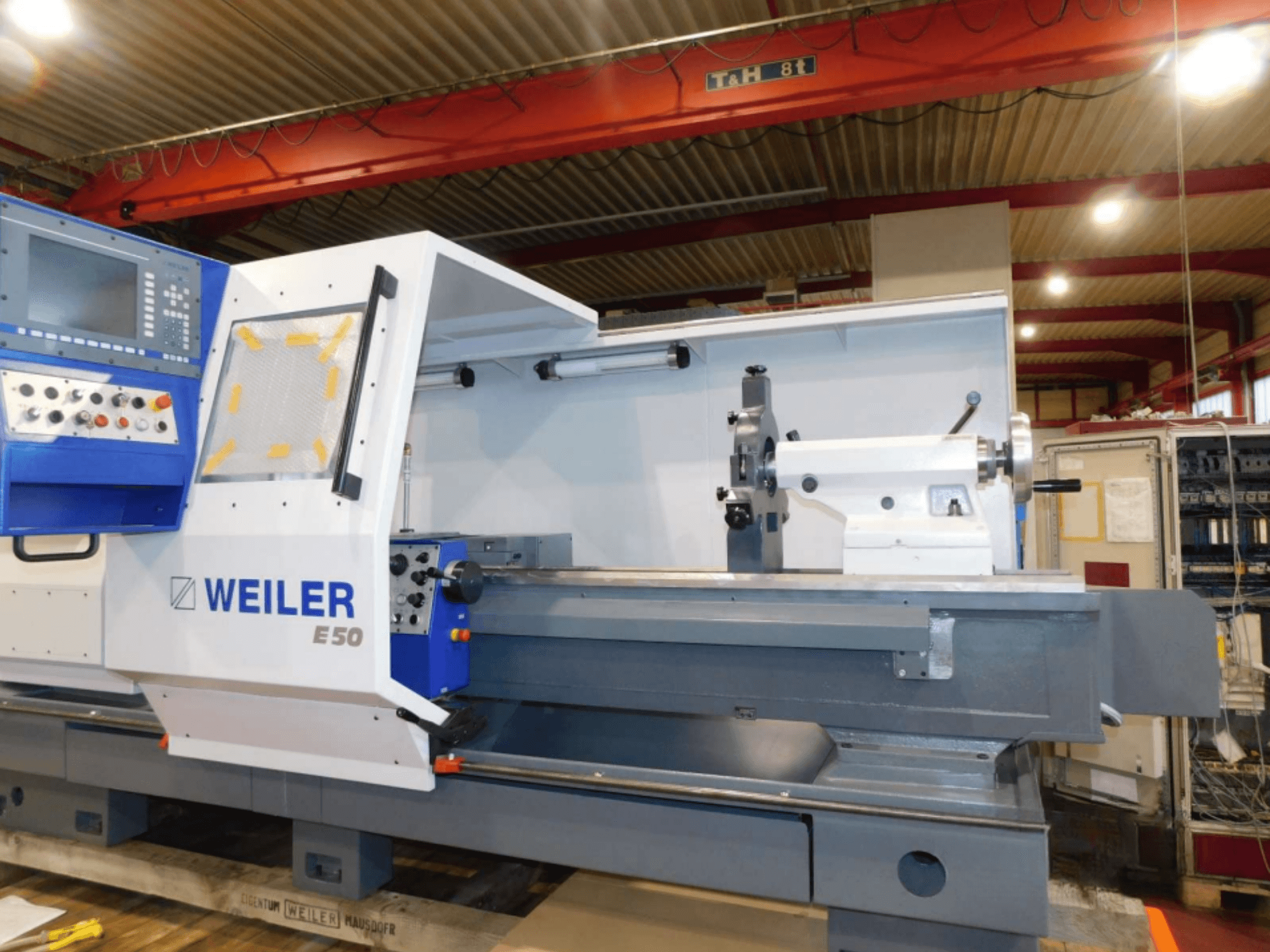 Weiler E50 horisontell svarv, vy framifrån, med kontrollpanel, spindel och precisionsbädd med tillbehör.