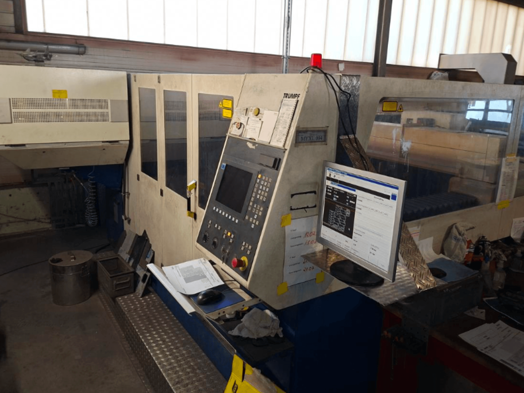 TRUMPF Trumatic L 4030 CO2-laserskärmaskin, framifrån med kontrollpanel och monitor, med arbetsytans detaljer synliga.