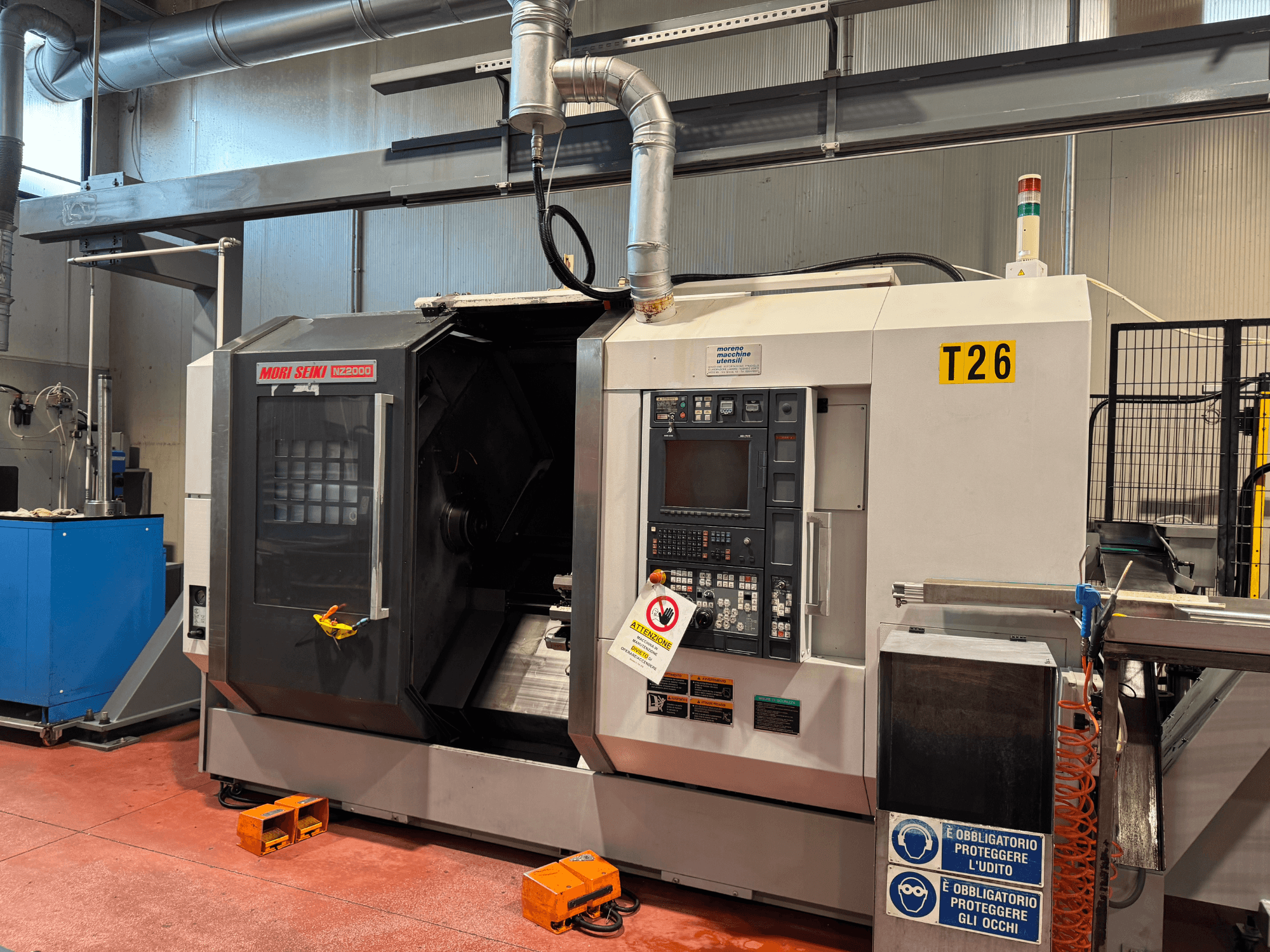 MORI SEIKI NZ-2000/T2/Y2 svarvcenter, framifrån, med kontrollpanel, säkerhetsskyltar och industriell uppställning.