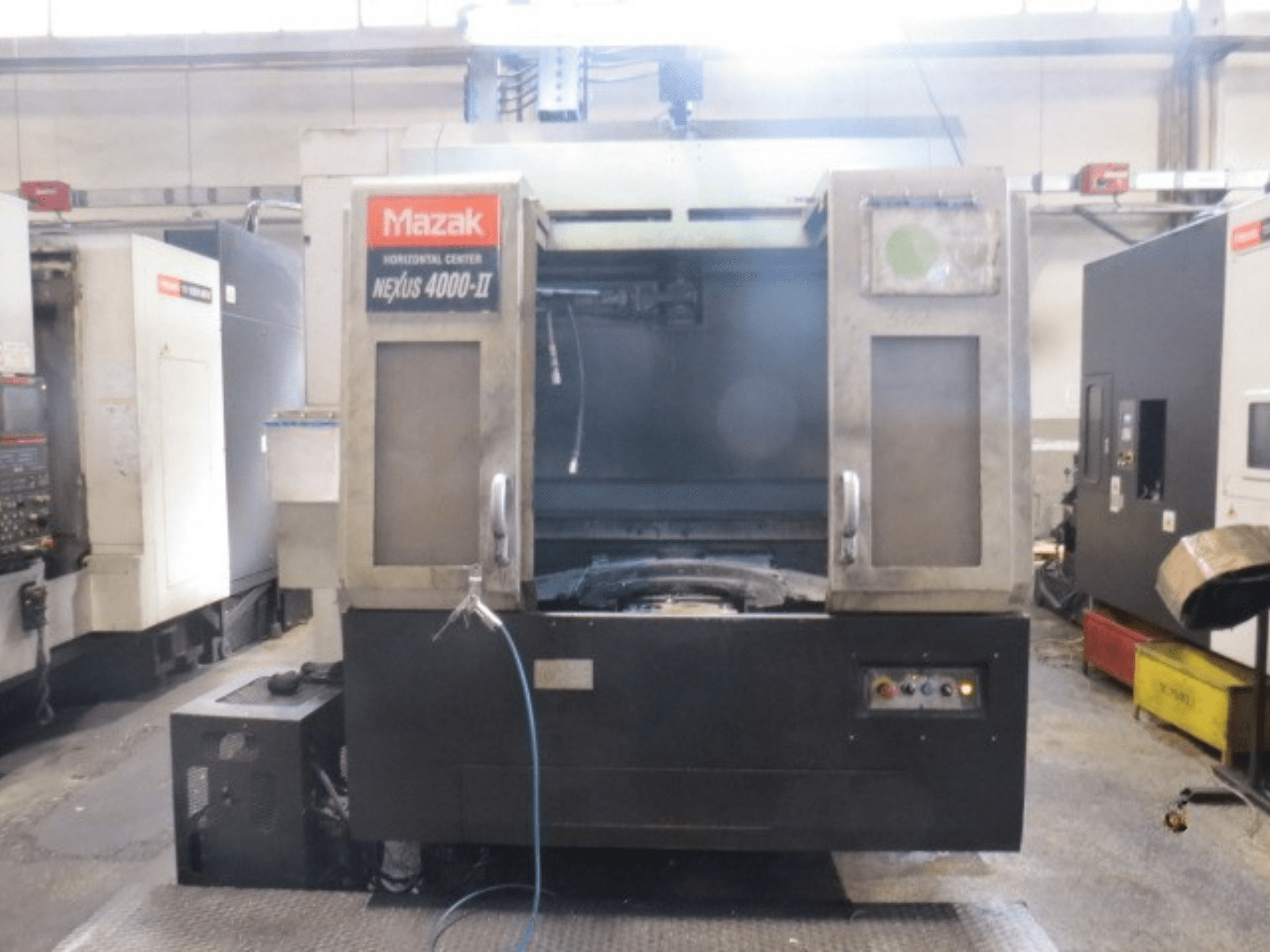 Mazak NEXUS 4000 II horisontellt bearbetningscenter, framifrån sett med kontrollpanelen, kylvätsketillförseln och det öppna arbetsområdet.