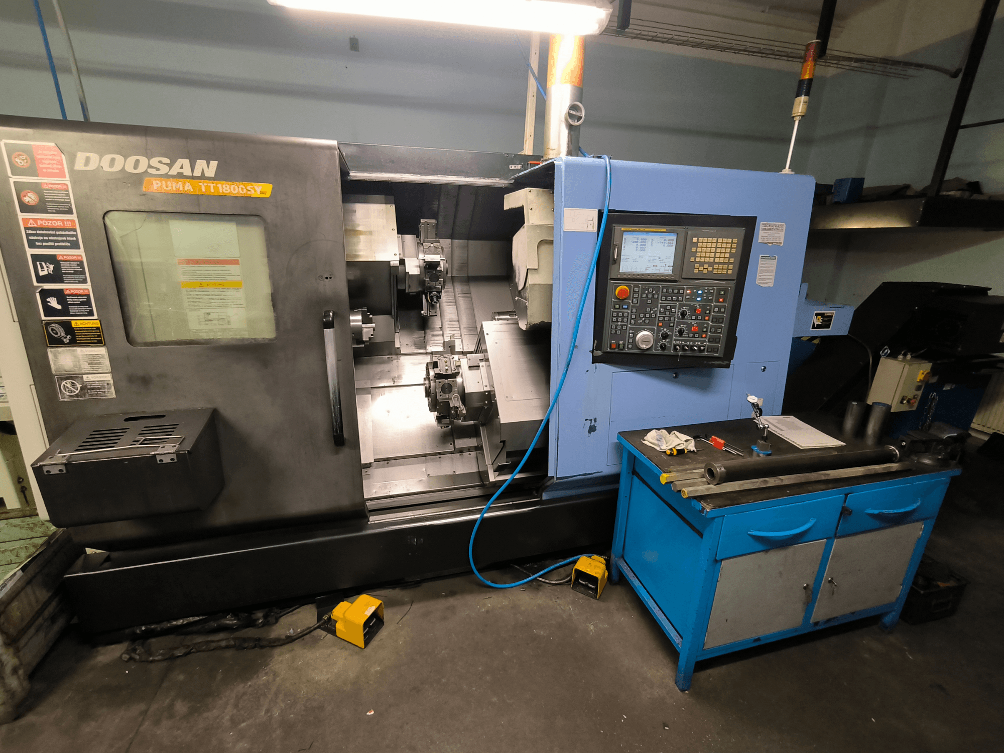 Doosan Puma TT1800SY CNC-svarv, framifrån, visar kontrollpanel, arbetsområde med verktyg och maskinkomponenter.