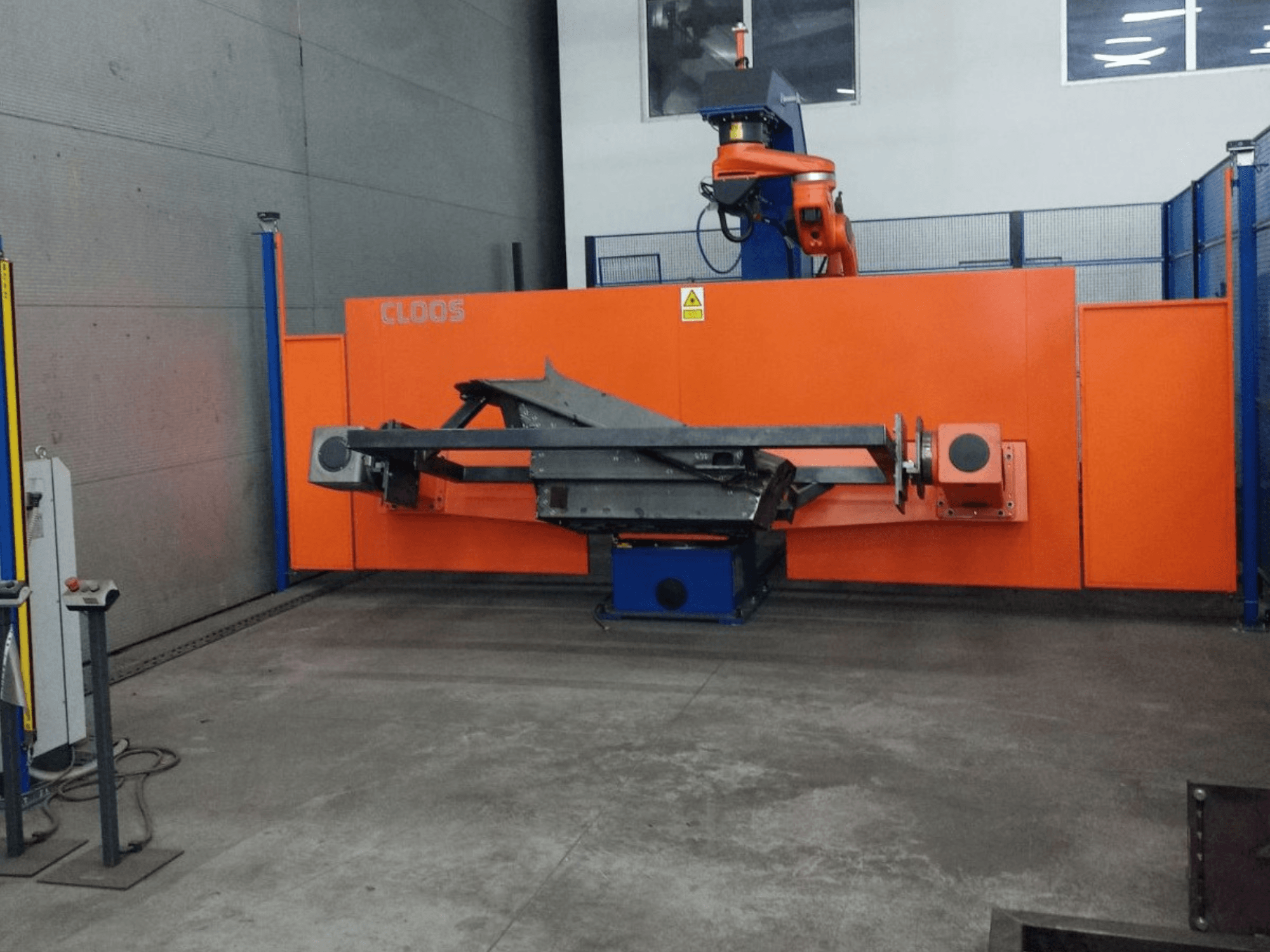 Frontvy av CLOOS QIROX QRC-350-E automationssystem med robotarm och metallstruktur i industriell miljö.