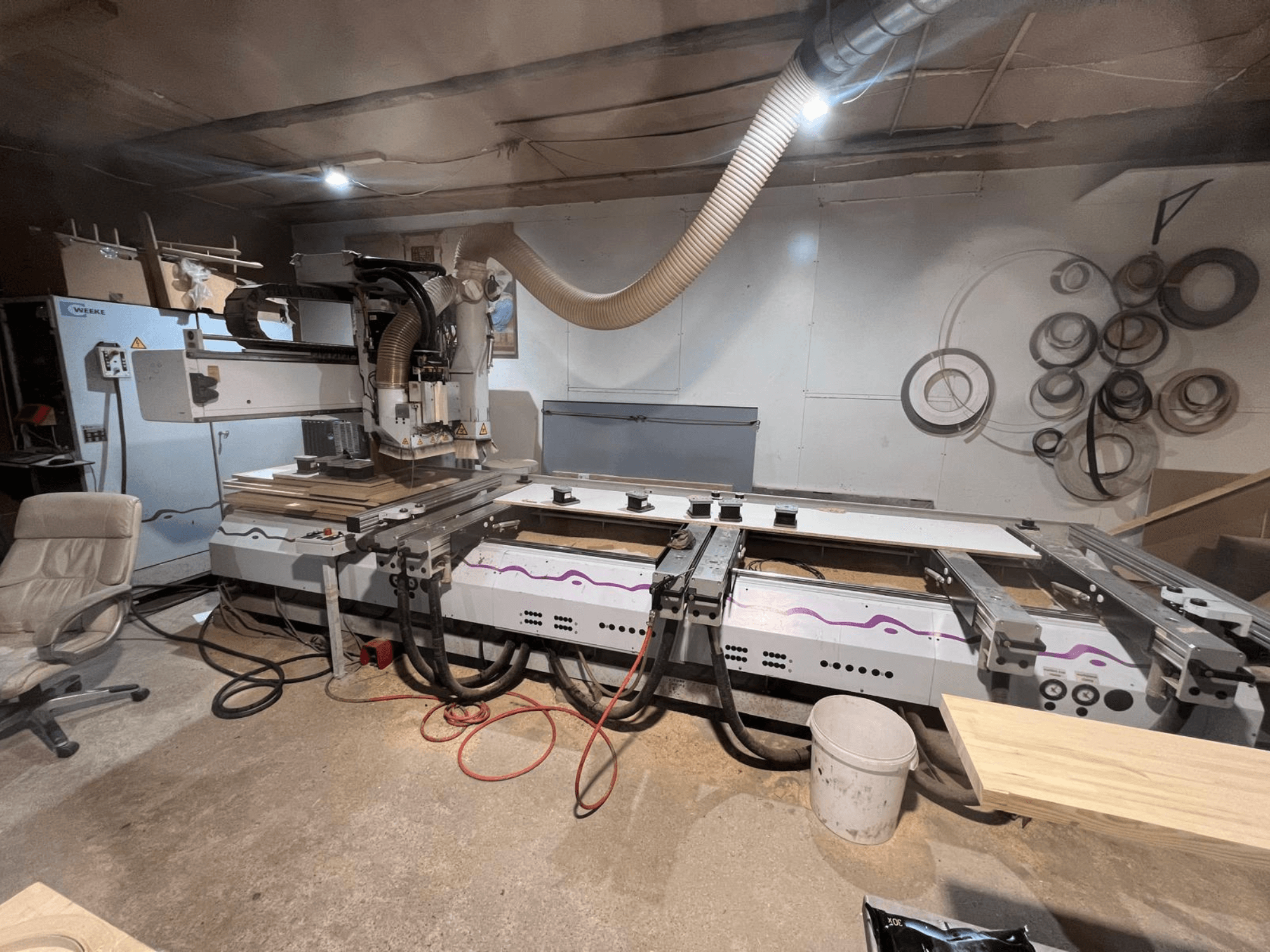 CNC-bearbetningscenter för trä Weeke OPTIMAT BP 120 i verkstaden, framifrån sett med träbitar och verktyg synliga på ytan.