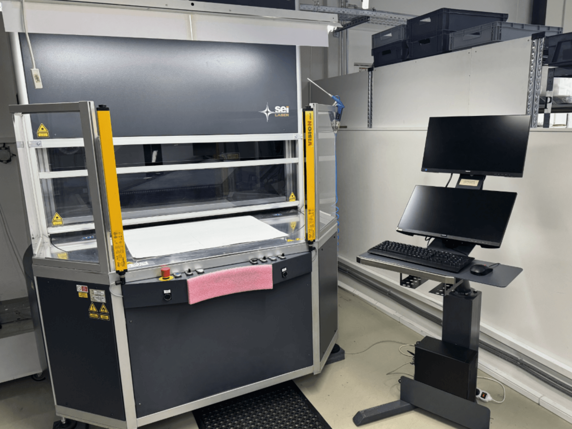 SEI Laser INFINITY 5070 V300 CO2-laserskärmaskin sett framifrån, med kontrollpanel och ansluten bildskärmsstation.
