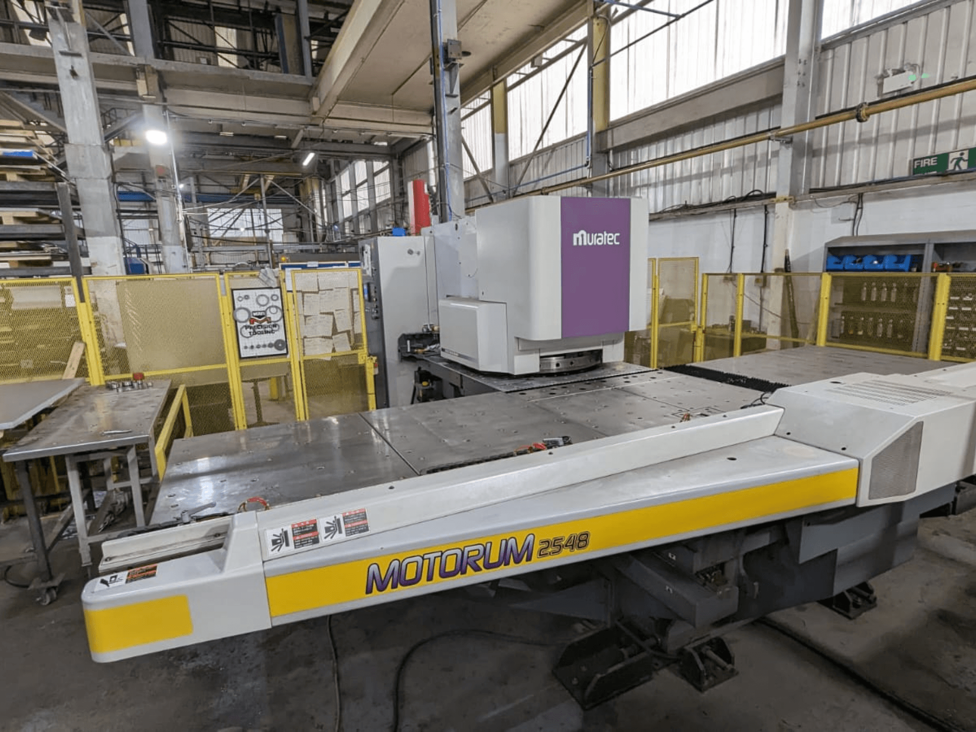 Muratec MOTORUM 2548 CNC-stansmaskin, framifrån sett med kontrollpanel och arbetsbord i en fabriksmiljö.