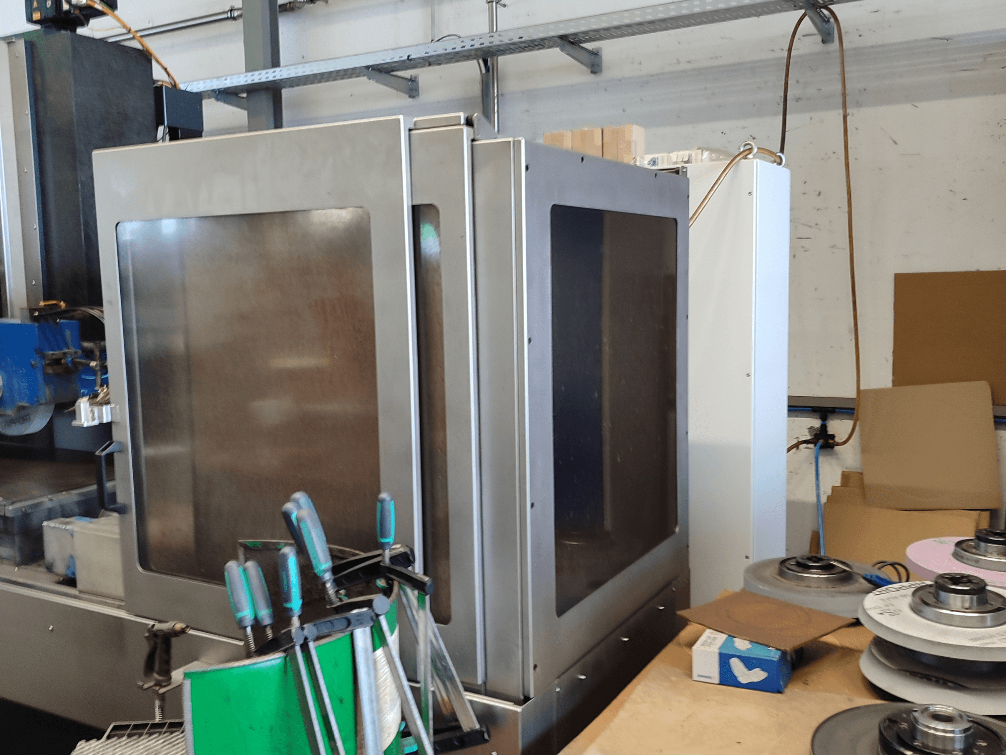 HEINZ STÖCKEL FD 1560 NC-T planslipmaskin, sidovy som visar metallhölje och slipkomponenter i verkstadsmiljö.