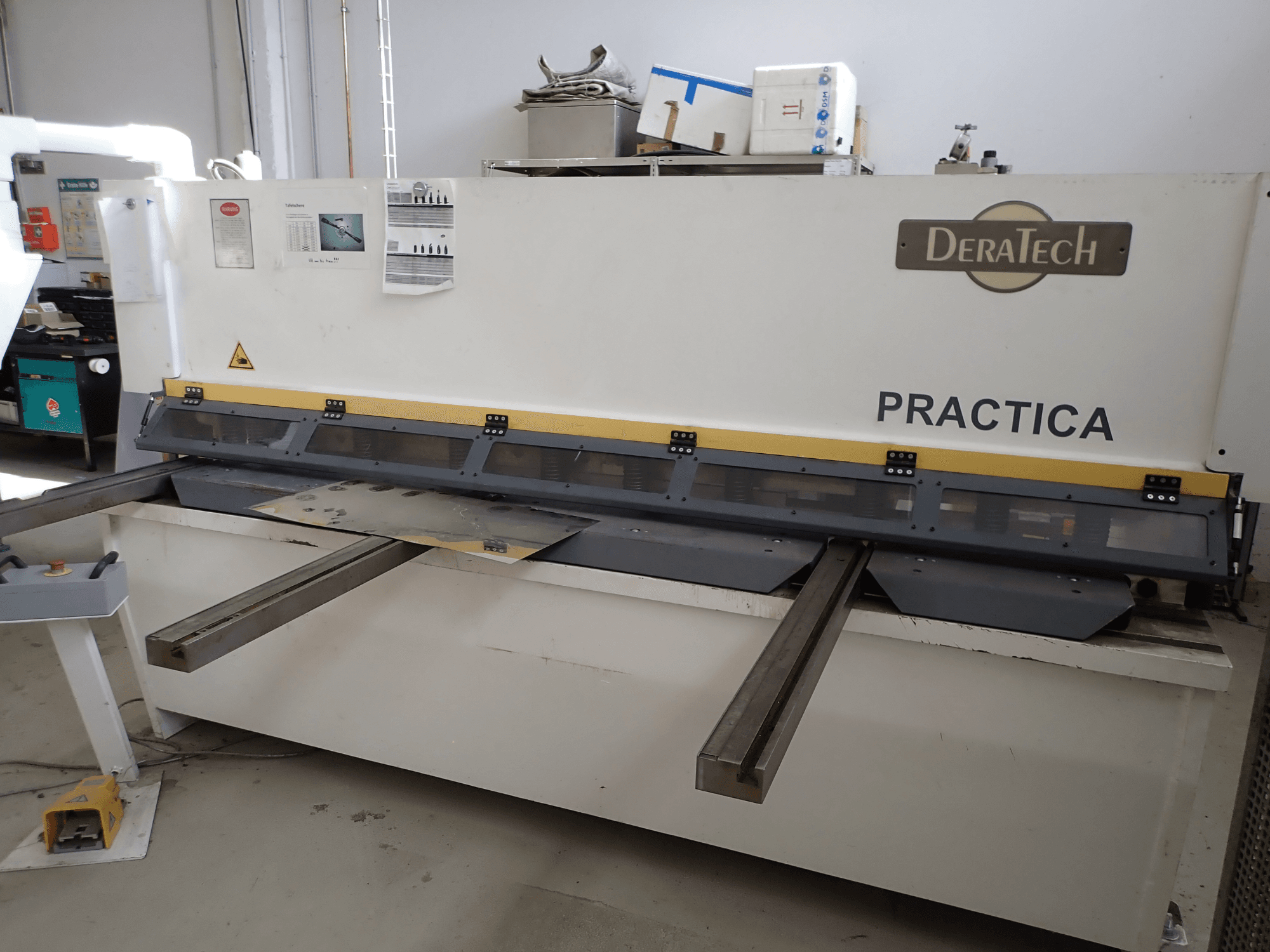 DERATECH Practica CNC-skärmaskin, framifrån, med skärblad och metallplåtar på arbetsytan.