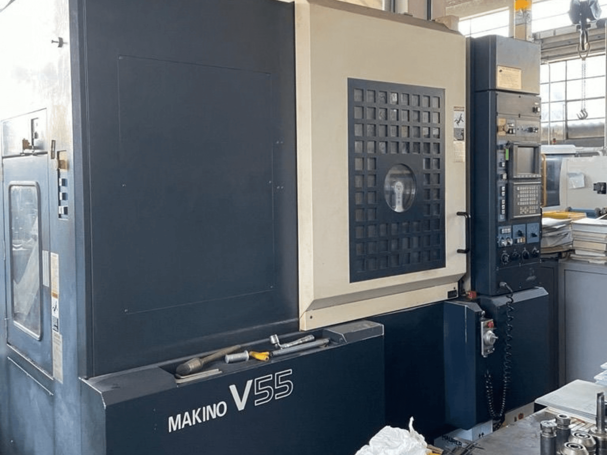 Vertikalt bearbetningscenter av typen Makino V55-A15, framifrån med kontrollpanelen, den robusta konstruktionen och arbetsytans utformning.
