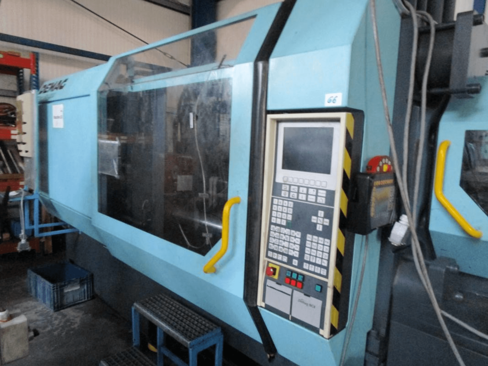 Demag Erdotech 500-3300 hydraulisk formsprutningsmaskin, framifrån, med kontrollpanel och tydlig säkerhetshölje.