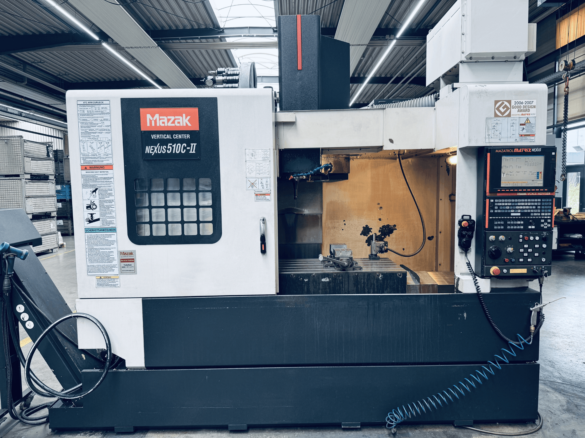 Mazak Vertical Center Nexus 510C-II, framifrån, med kontrollpanelen, arbetsområdet och driftsfunktionerna i en verkstadsmiljö.
