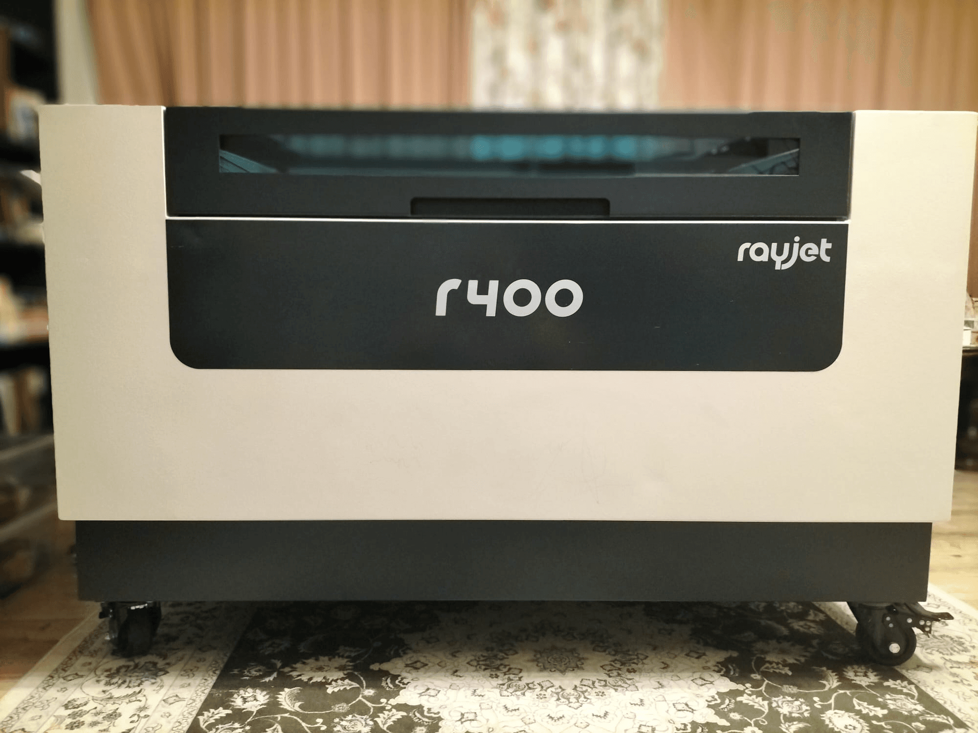 Framsidan av Trotec Rayjet R400 lasergravyrmaskin, som visar sin eleganta design och tydliga varumärkesprofilering.