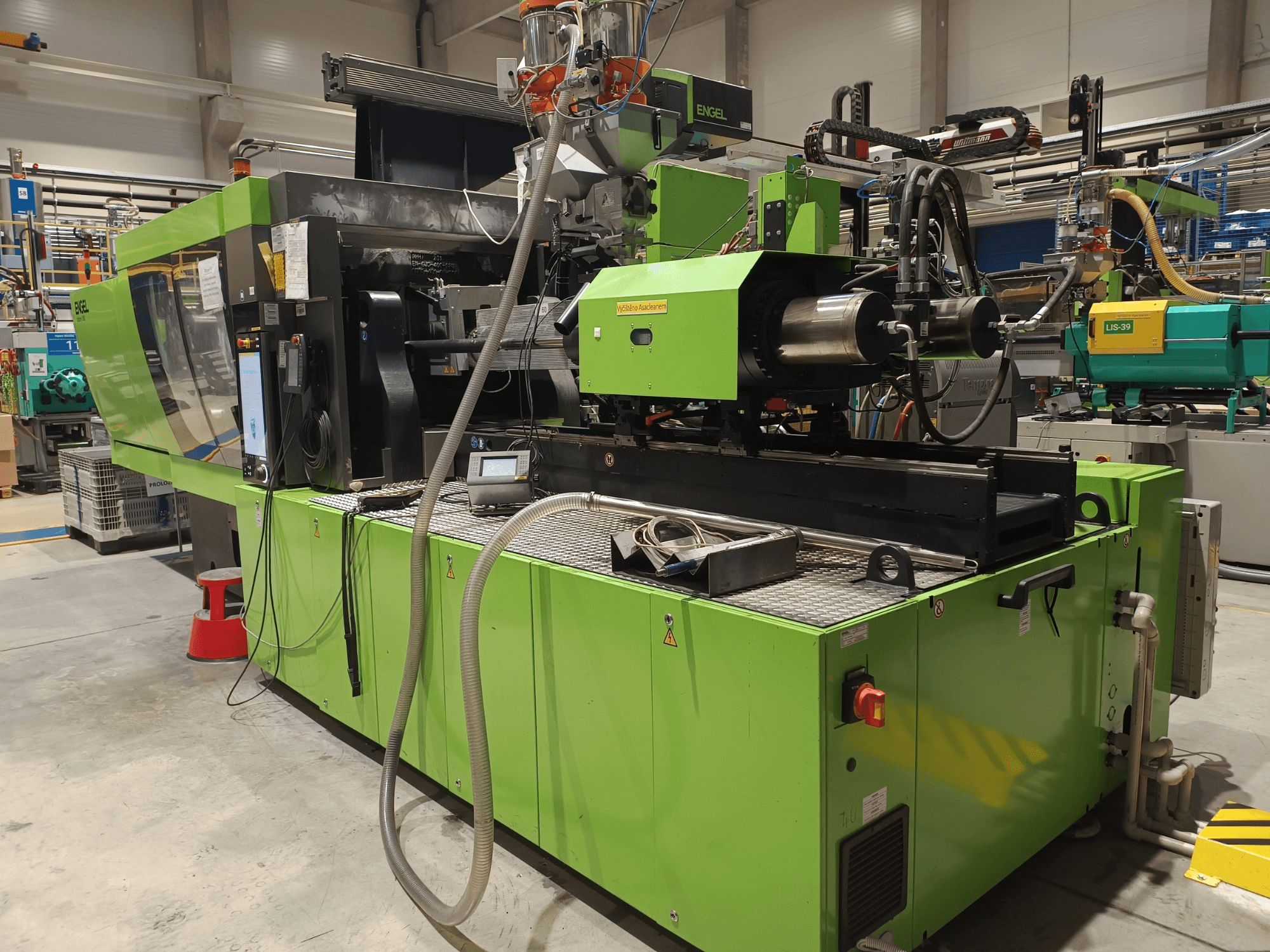 Engel formsprutningsmaskin, sidovy, grön exteriör, med synlig pekskärmspanel och hydrauliska komponenter.