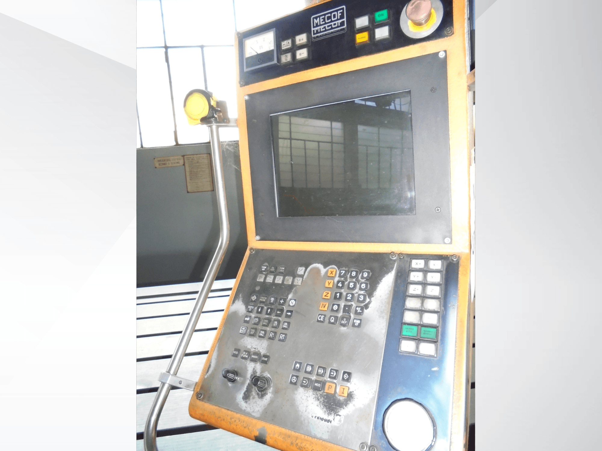 Mecof kontrollpanel med digital display, knappar och vred; framifrån syns slitage på kontrollerna.