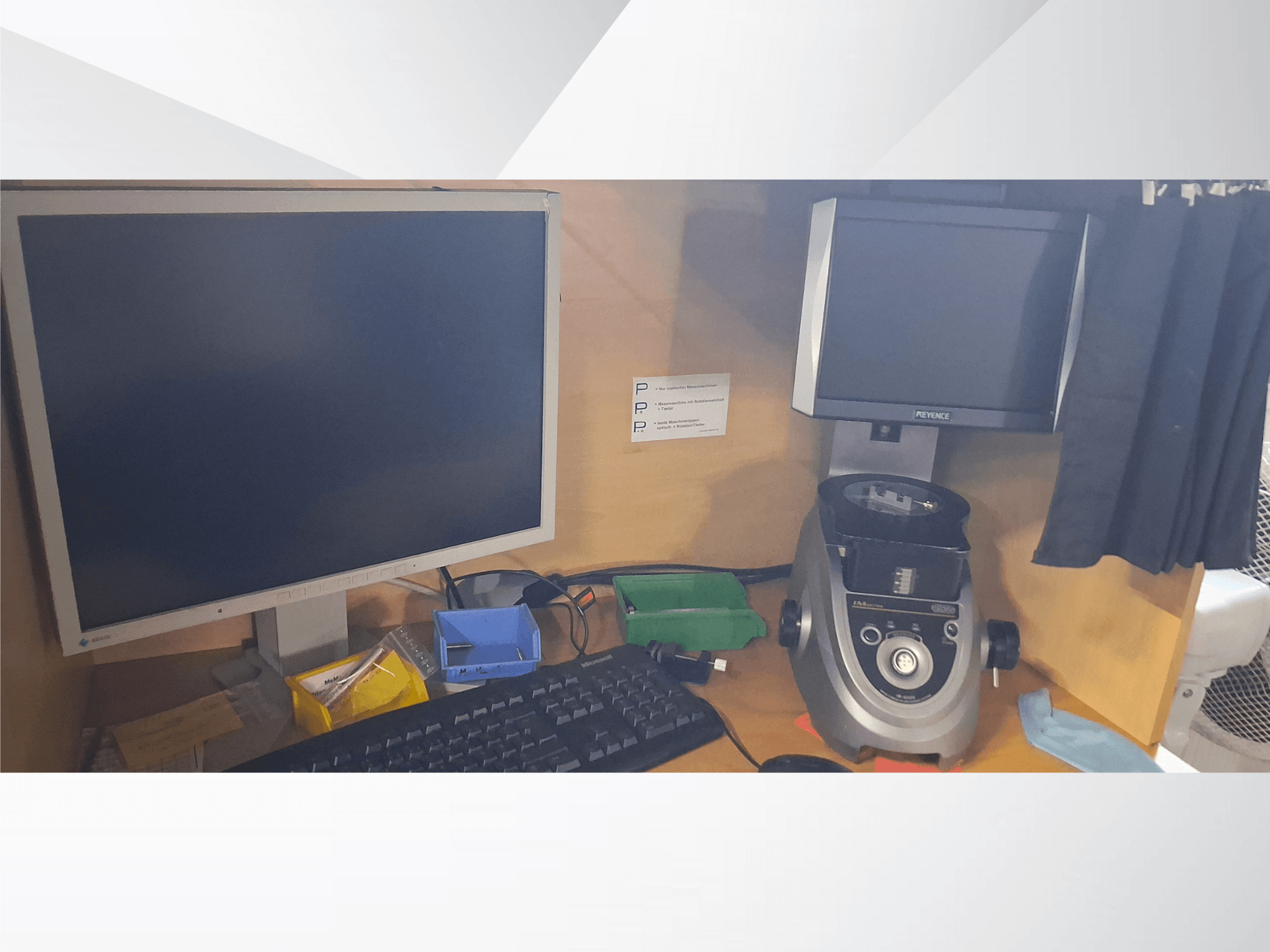 Datorskärm med tangentbord, PEVA-märkt display och en grå labbutrustning på ett träbord med diverse brickor och papper.