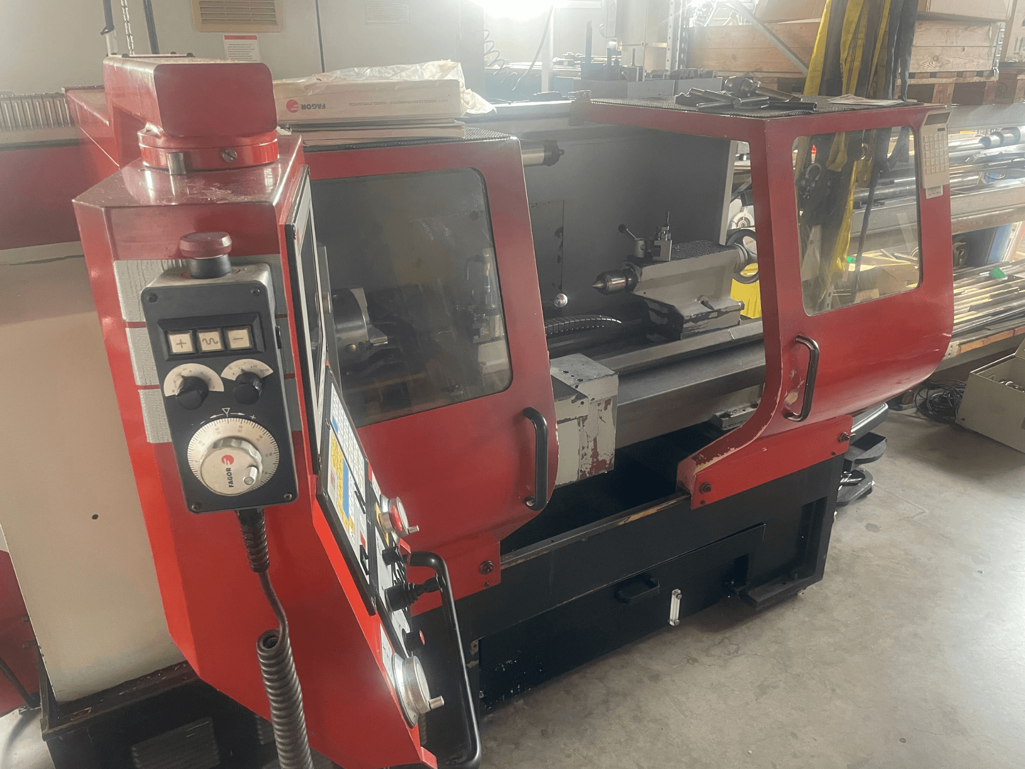 EMCO EMCOMAT 200X1000 horisontell svarv, sidovy, som visar manöverelement, skåp med fönster och svarvens uppställning.