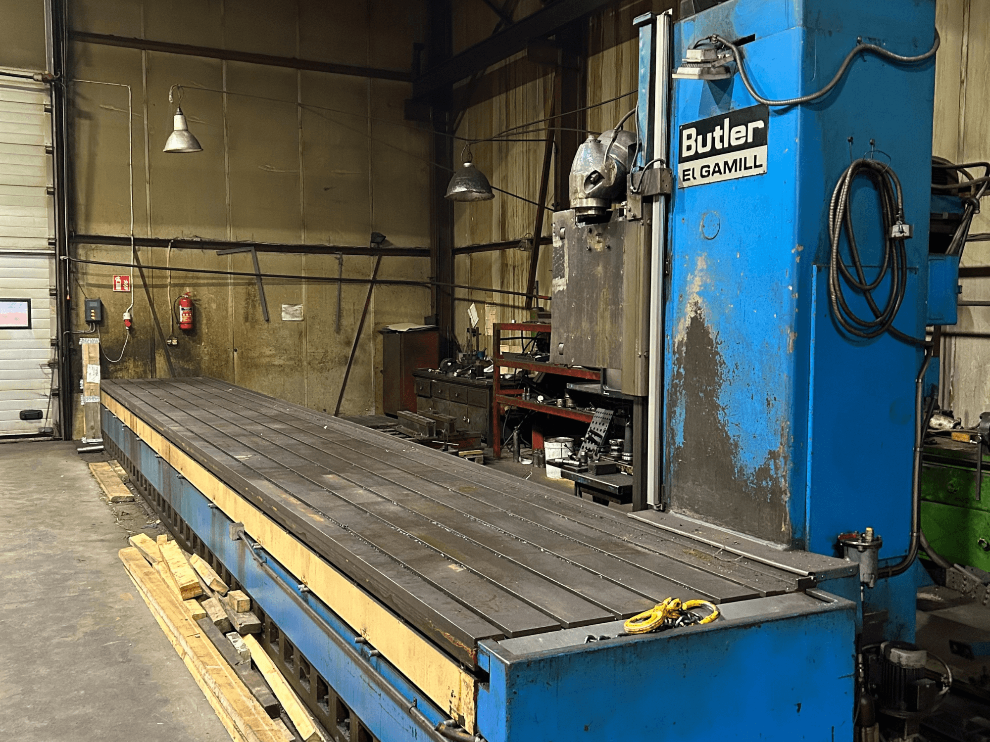 Blue Butler El Gamill fräsmaskin i en verkstad, sidovy med ett långt plant bord och reglage till höger.