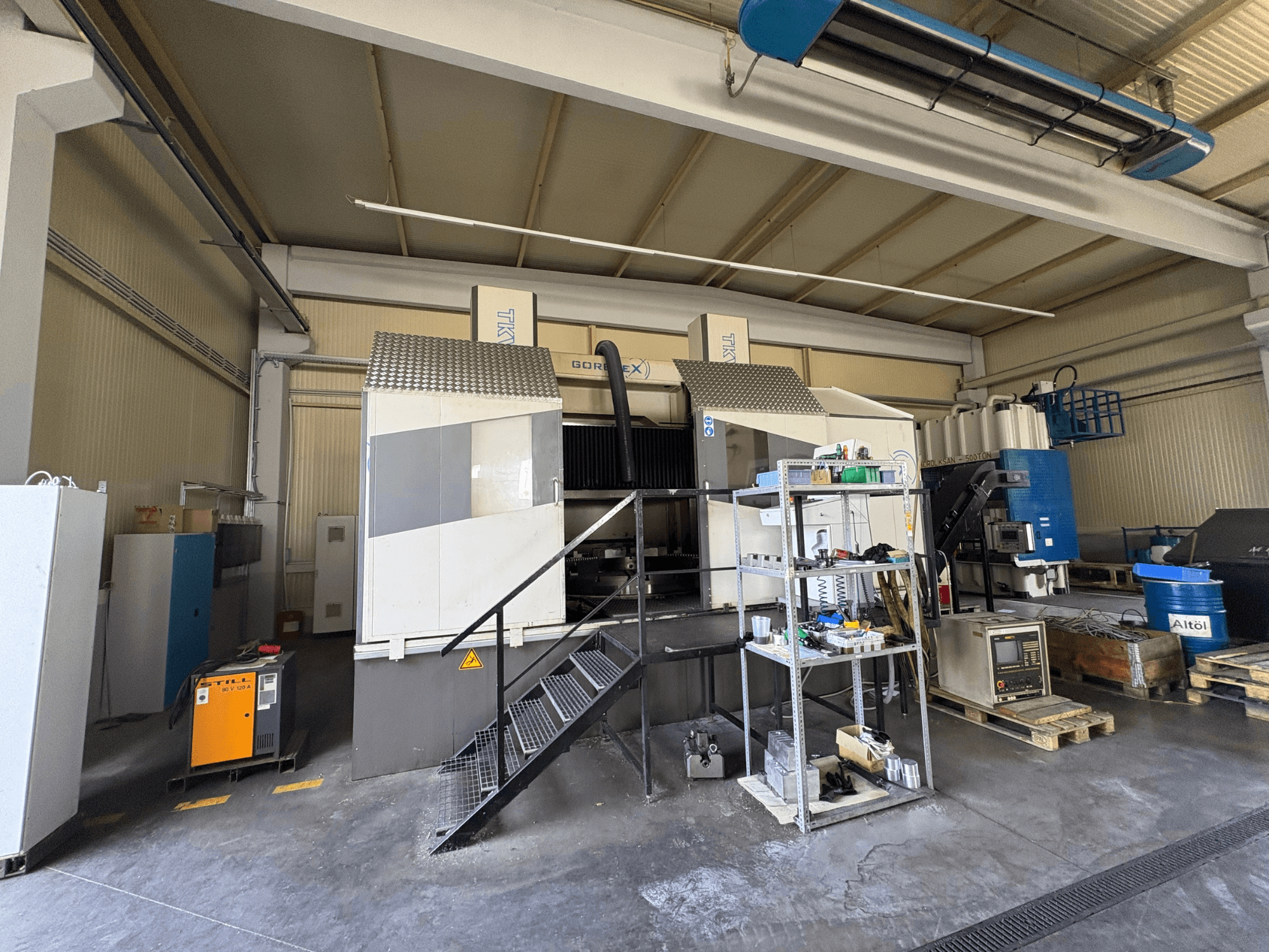 Uppställning för industriell bearbetning med GORAT X-maskin, vy från sidan; inkluderar verktyg, kontrollpanel och utrustning på hyllor.