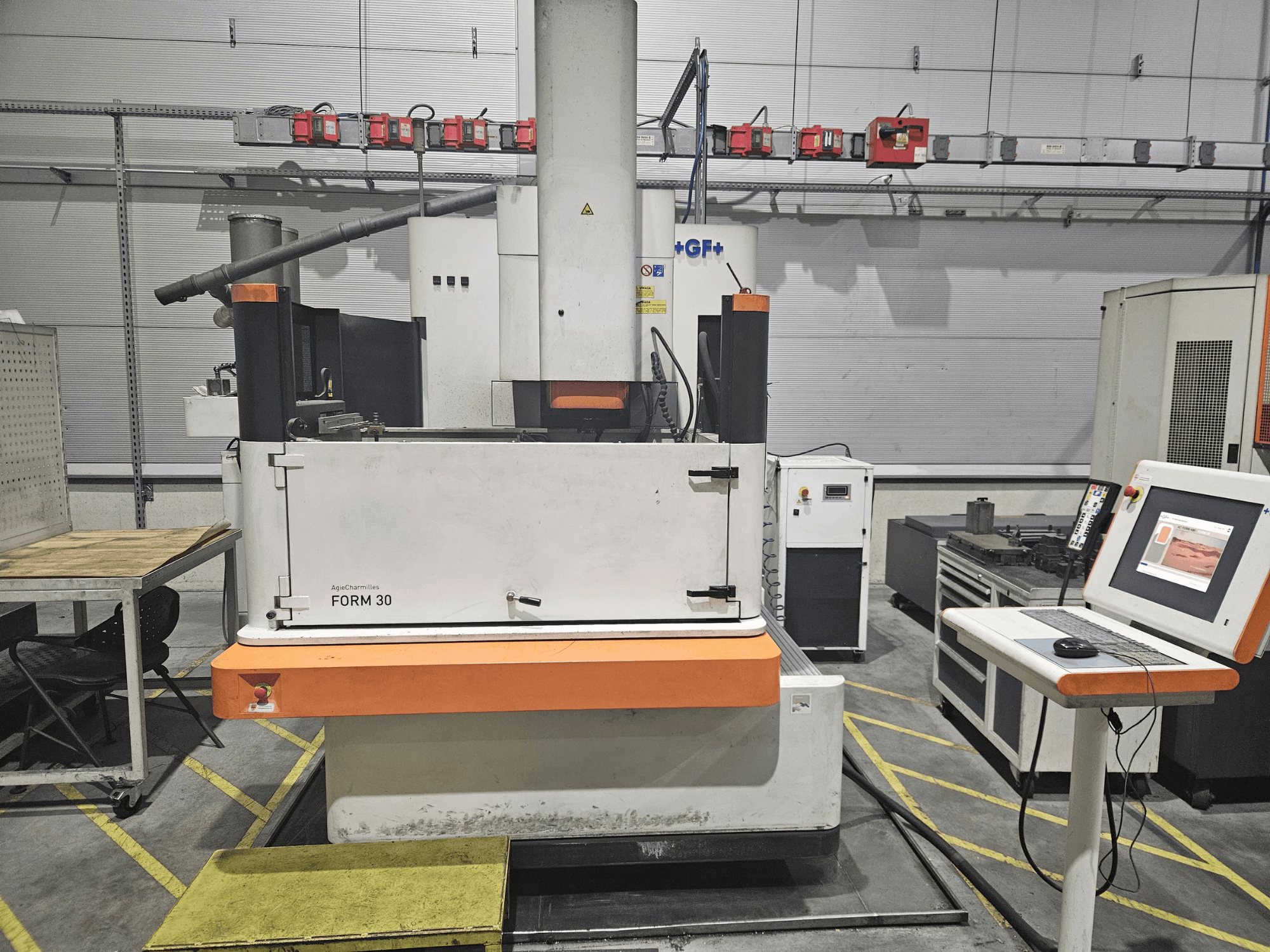 ApeqChemicals FORM 30-maskin i en verkstad, vy framifrån med kontrollpanel och arbetsbord vid sidan.