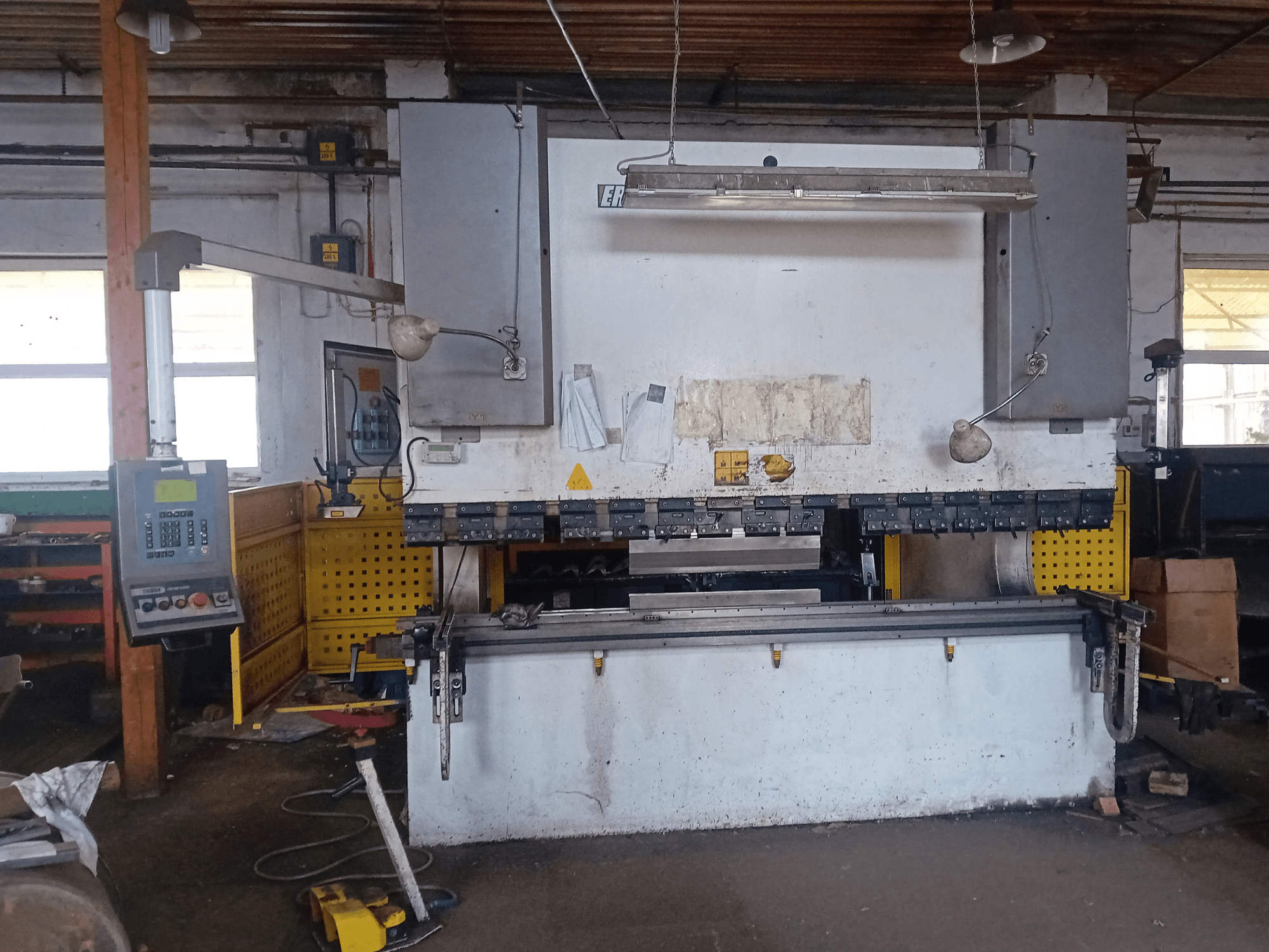 ERMAK CNC HAP 3100x300 hydraulisk press visad framifrån, med kontrollpanel och arbetsbänk i en verkstadsmiljö.