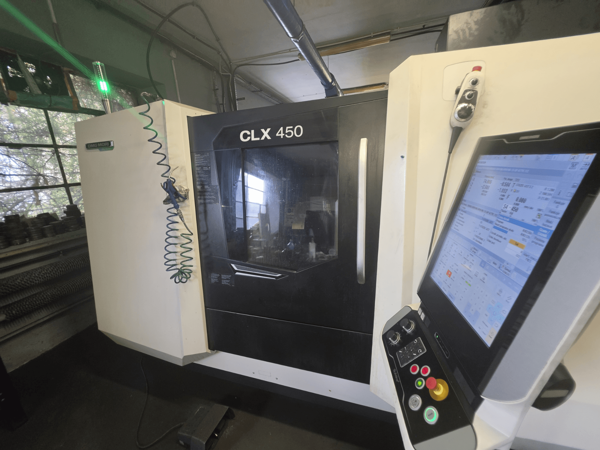 DMG MORI CLX 450 V3 horisontell svarv, framifrån sett med kontrollpanel och skärm som visar driftsdata.