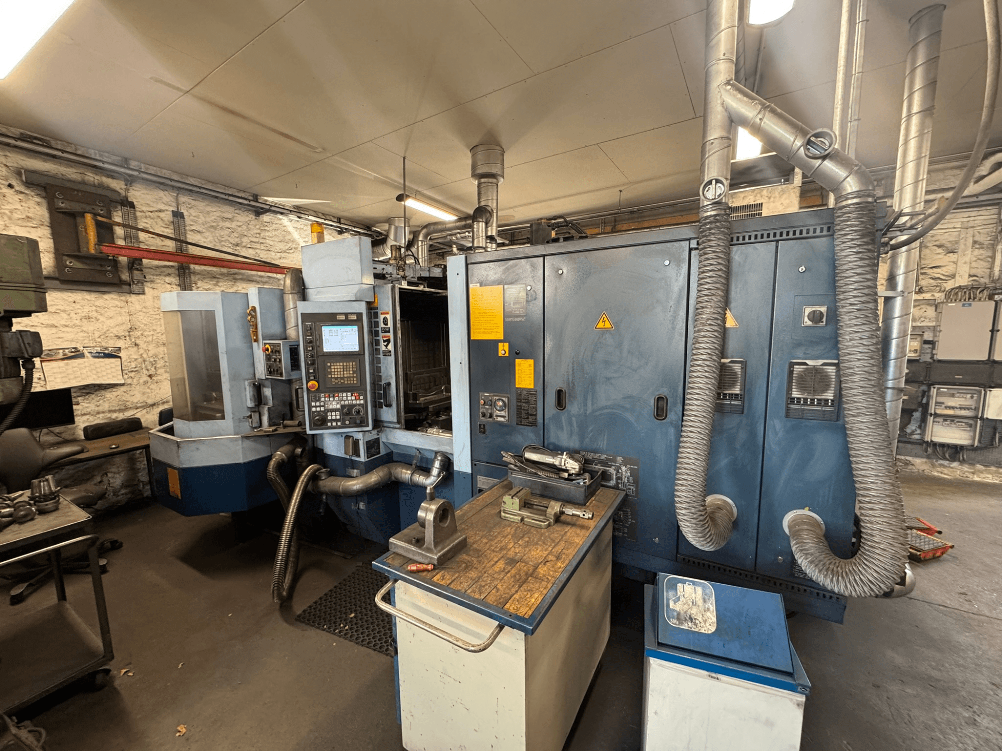 Matsuura H.PLUS-300 horisontellt bearbetningscenter i en verkstad, sett framifrån, med kontrollpanelen och arbetsbordet synliga.