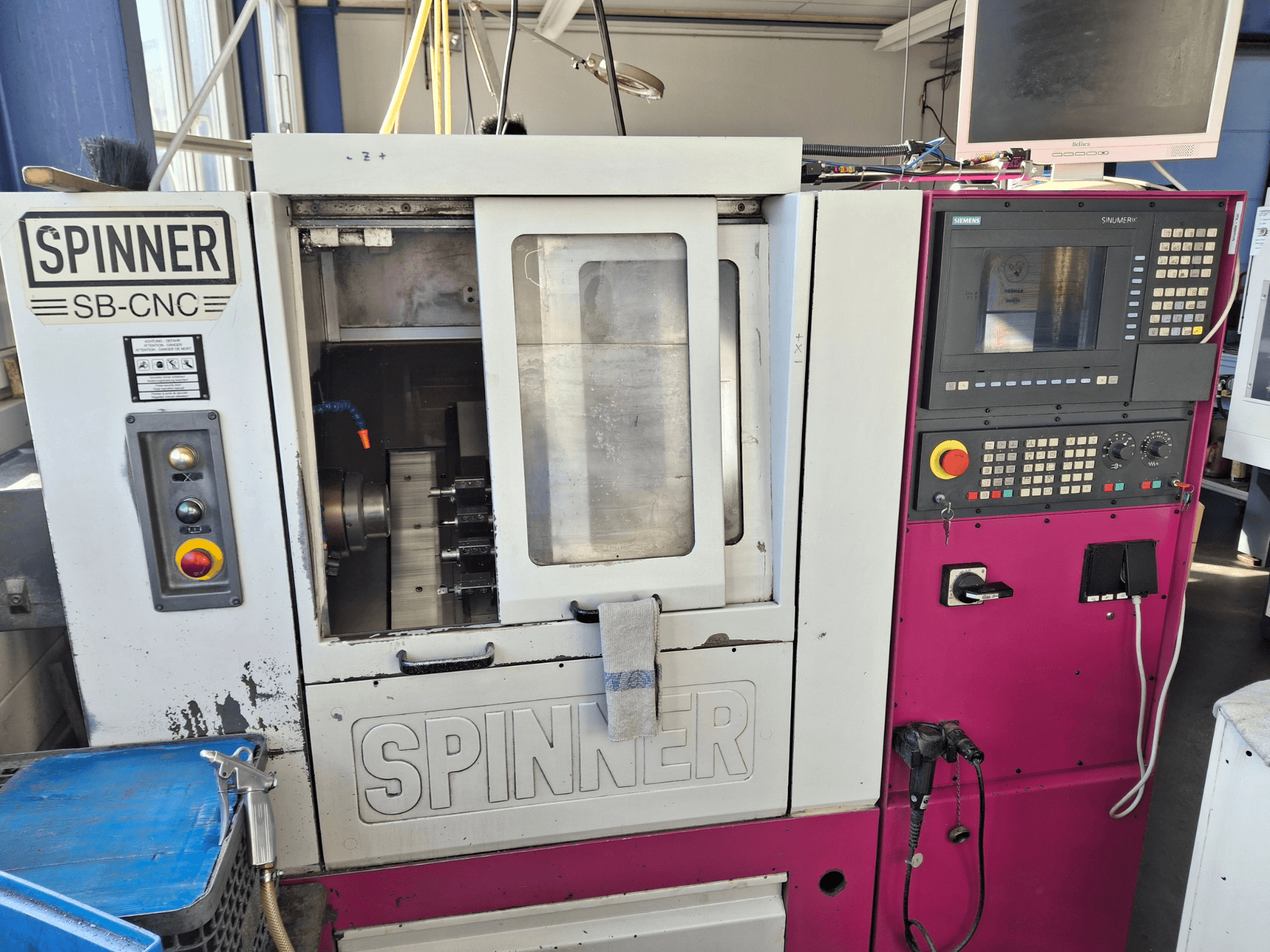 Horisontell svarv SPINNER SB-CNC, framifrån med kontrollpanel, verktygshållare och driftindikatorer.