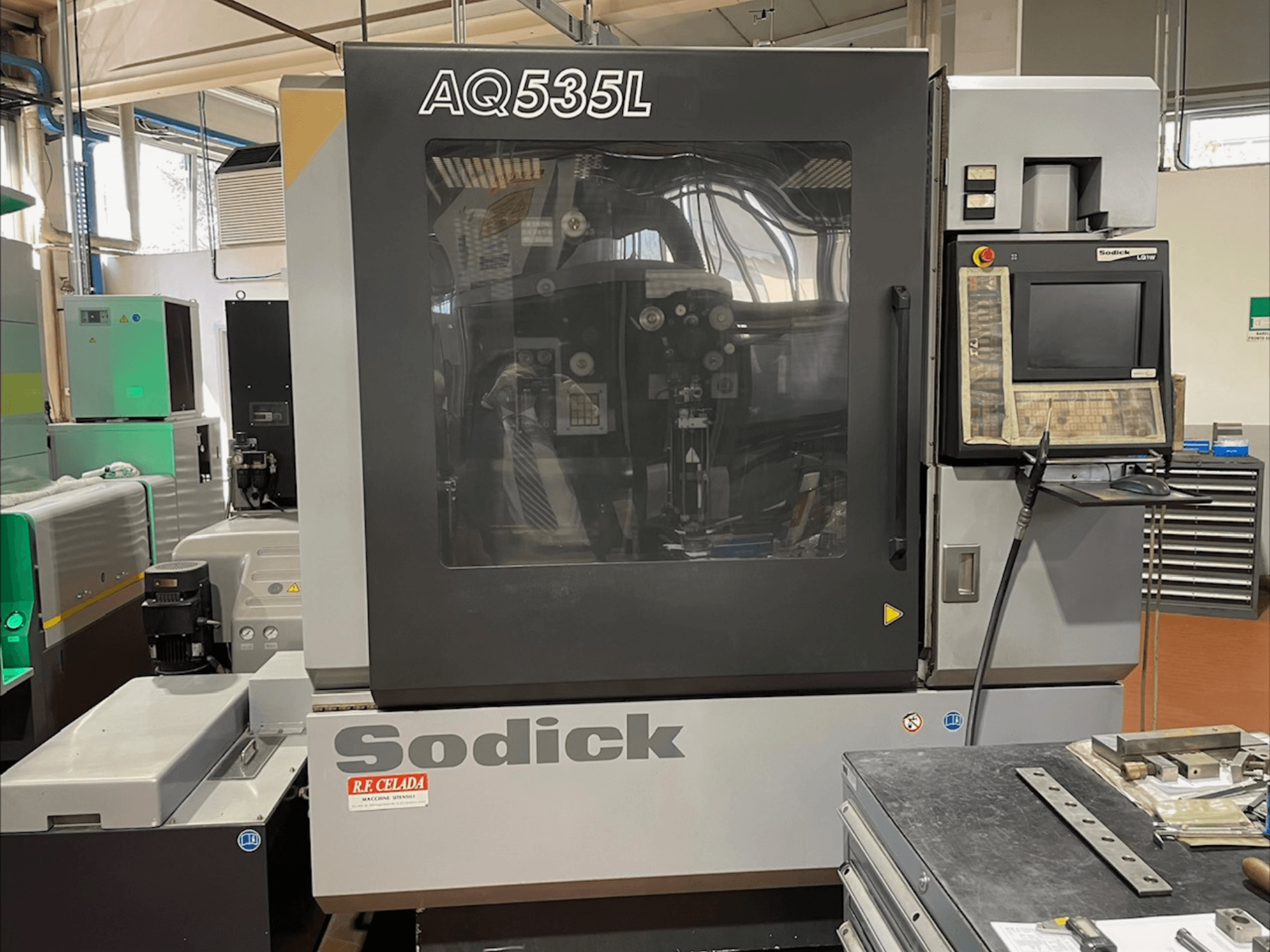 Sodick AQ535L Wire EDM-maskin framifrån, med kontrollpanel och genomskinligt skyddshölje.
