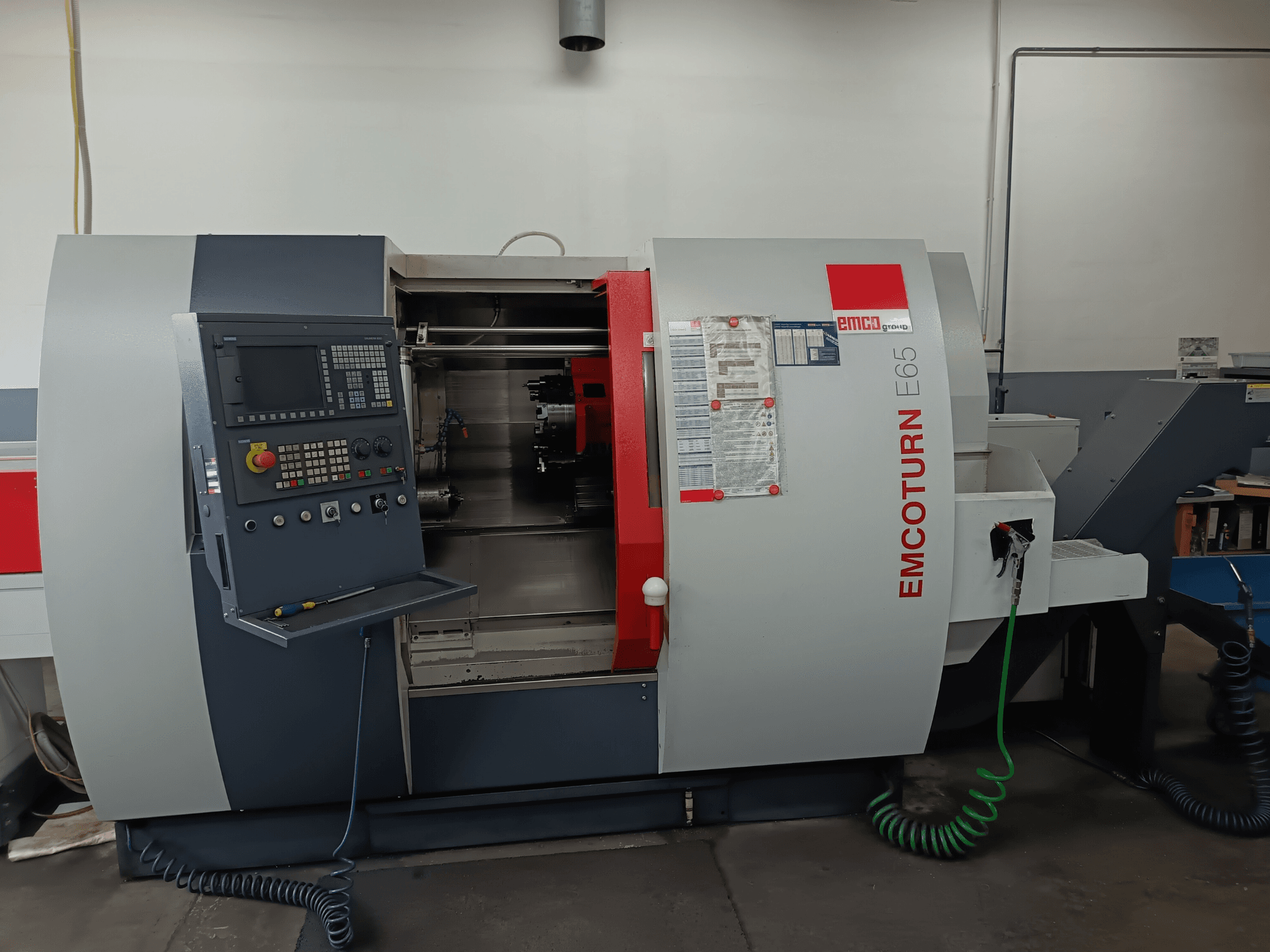 EMCO EMCOTURN E65 vändskivefräs, framifrån med kontrollpanel, inre mekanism och funktioner i verkstadsmiljö.