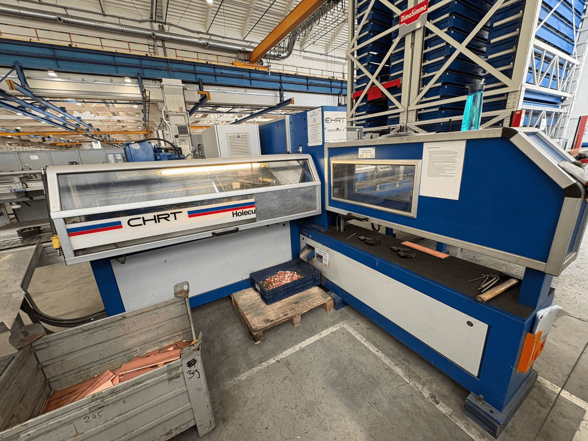 CNC-stansmaskin EHRT Holecut 40-9, framifrån, med kontrollpanel, metallbehållare och kopparplåtar i närheten.