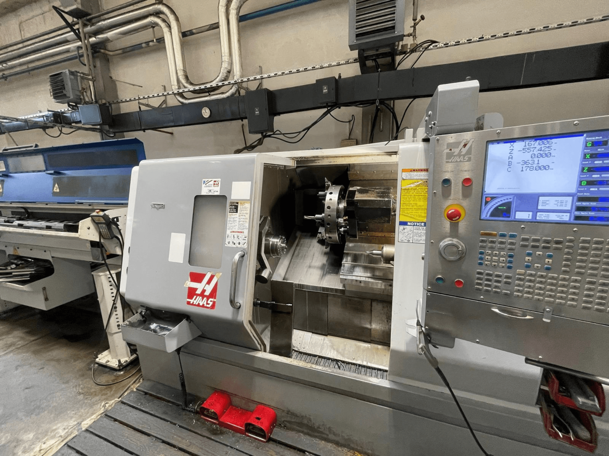 Haas SL-30THE – en horisontell svarv i en verkstad, utrustad med en digital kontrollpanel och ett öppet arbetsområde.