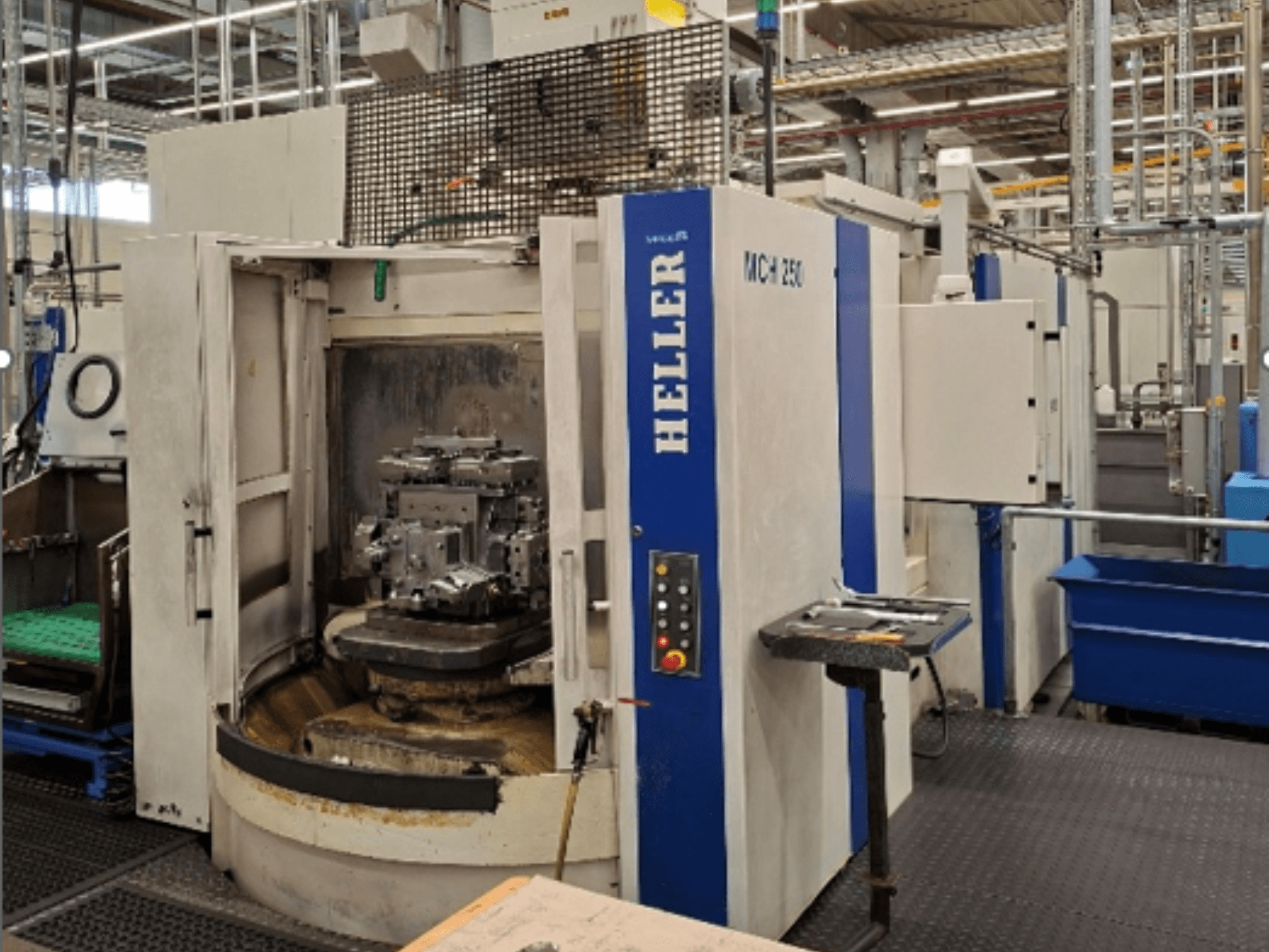 Heller MCH 250, ett horisontellt bearbetningscenter, sett framifrån, med ett arbetsstycke på ett roterande bord och en kontrollpanel.