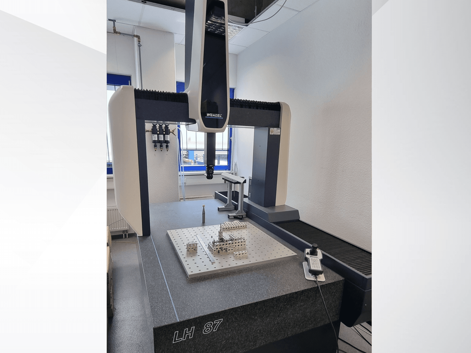 Wenzel LH 87 CMM i ett laboratorium, framifrån sett med mätproben placerad över en precisionsmätplatta och den digitala styrenheten synlig.