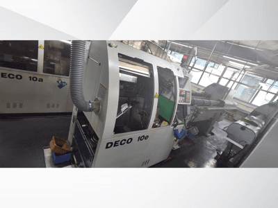 DECO 10e CNC-maskin i sidovy, med kontrollpanel, grön inredning och ansluten avgasslang.