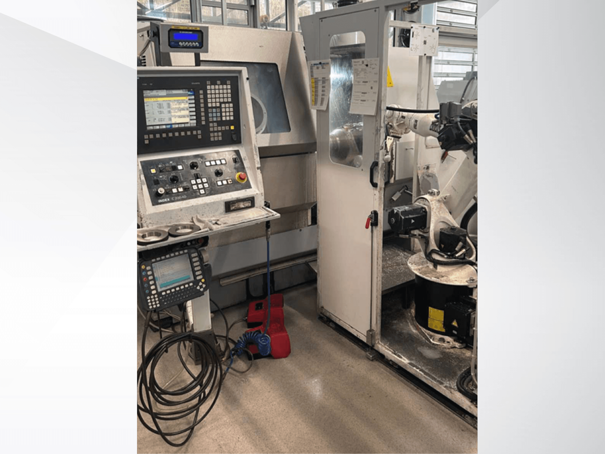 Frontvy av Index G 200 RATIO LINE svarvfräsmaskin med kontrollpanel, robotarm och arbetsyta för drift.