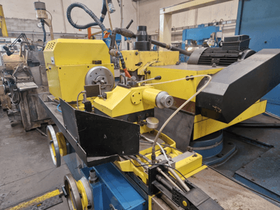 Gul industrimaskin med svart sektion, med ratt och slangar, sedd framifrån i en liten vinkel.