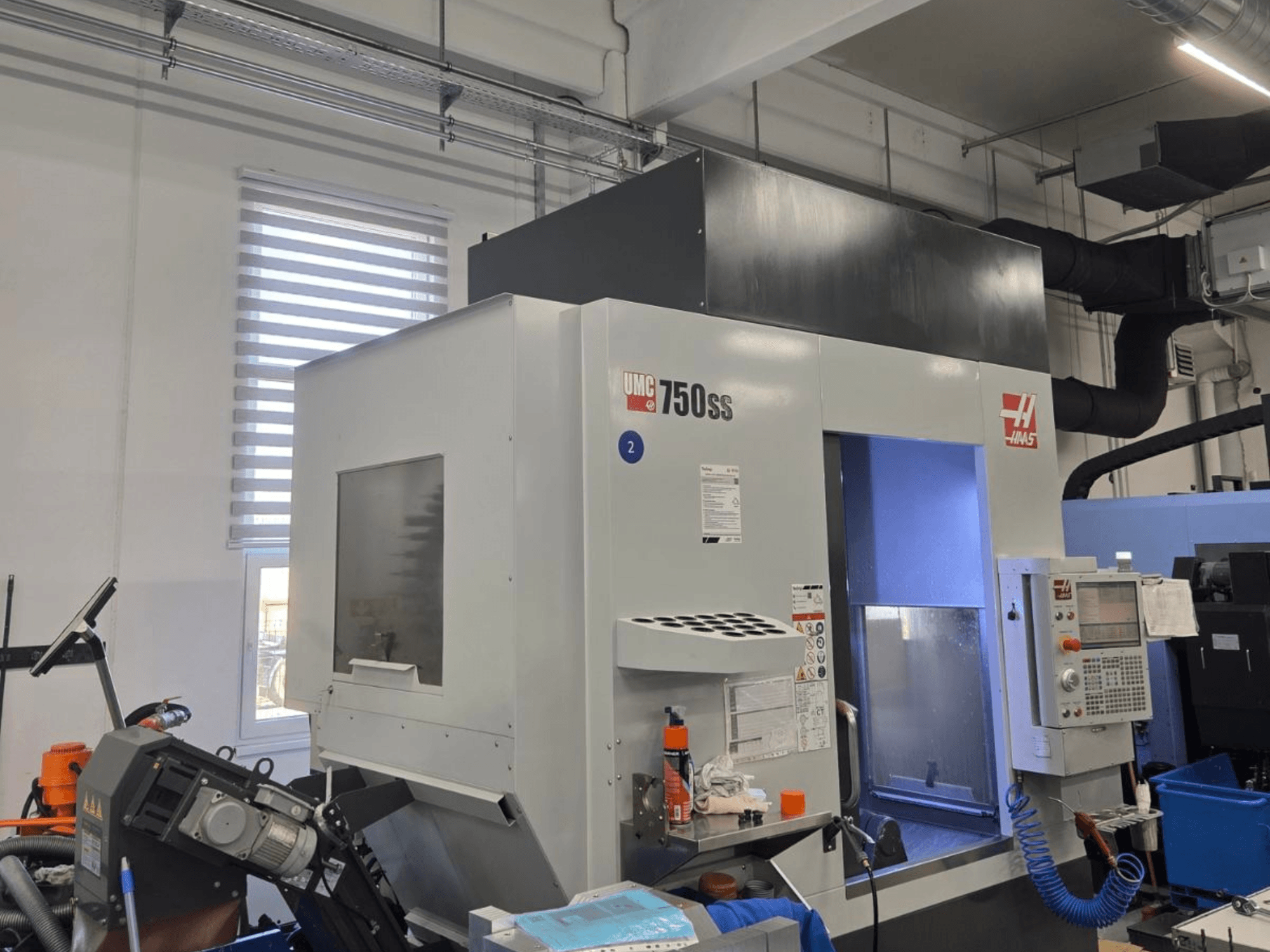 Haas UMC-750SS vertikala fleroperationsmaskin, framifrån, med kontrollpanel och fri tillgång till bearbetningsområdet.