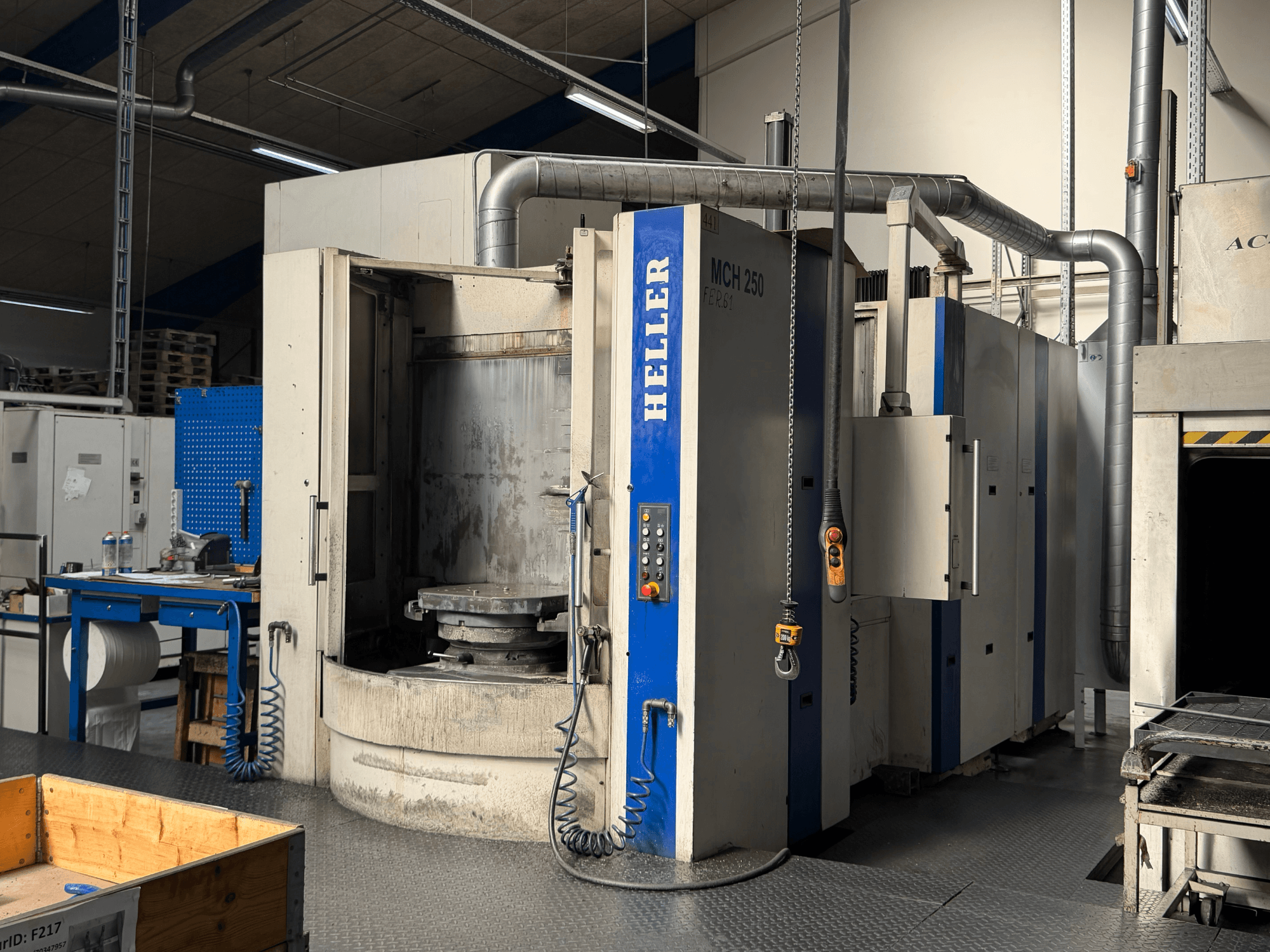 Frontvy av HELLER MCH 250 horisontell fleroperationsmaskin med kontrollpanel, stort roterande bord och industrimiljö.