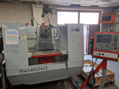 INTOS FNG40CNC-maskin, vy framifrån, med kontrollpanel, operativa delar och ett arbetsbord av metall. Idealisk för maskinbearbetning.