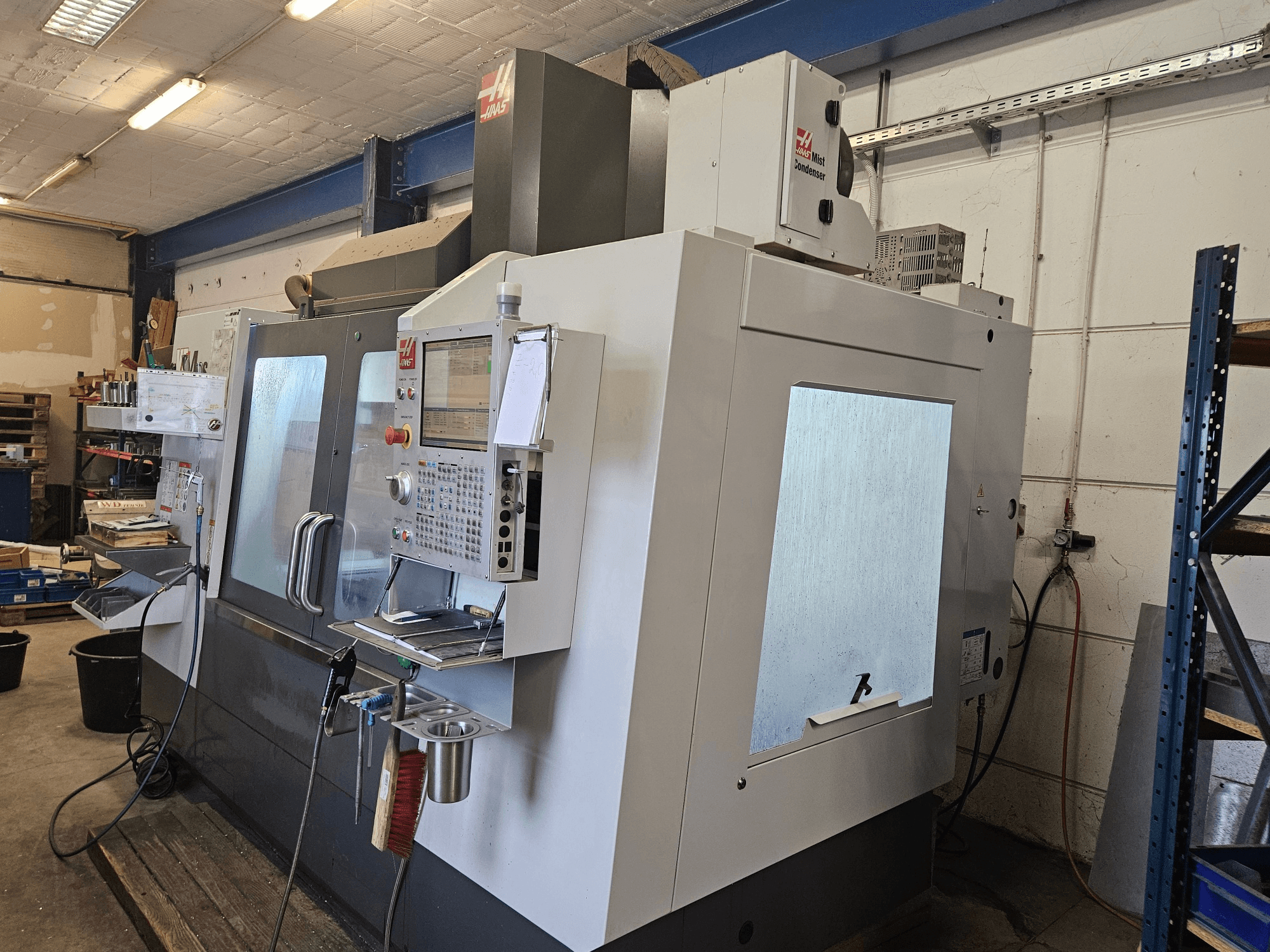 HAAS VF-4SS vertikalt bearbetningscenter sett framifrån, med en kontrollpanel och stora fönster.