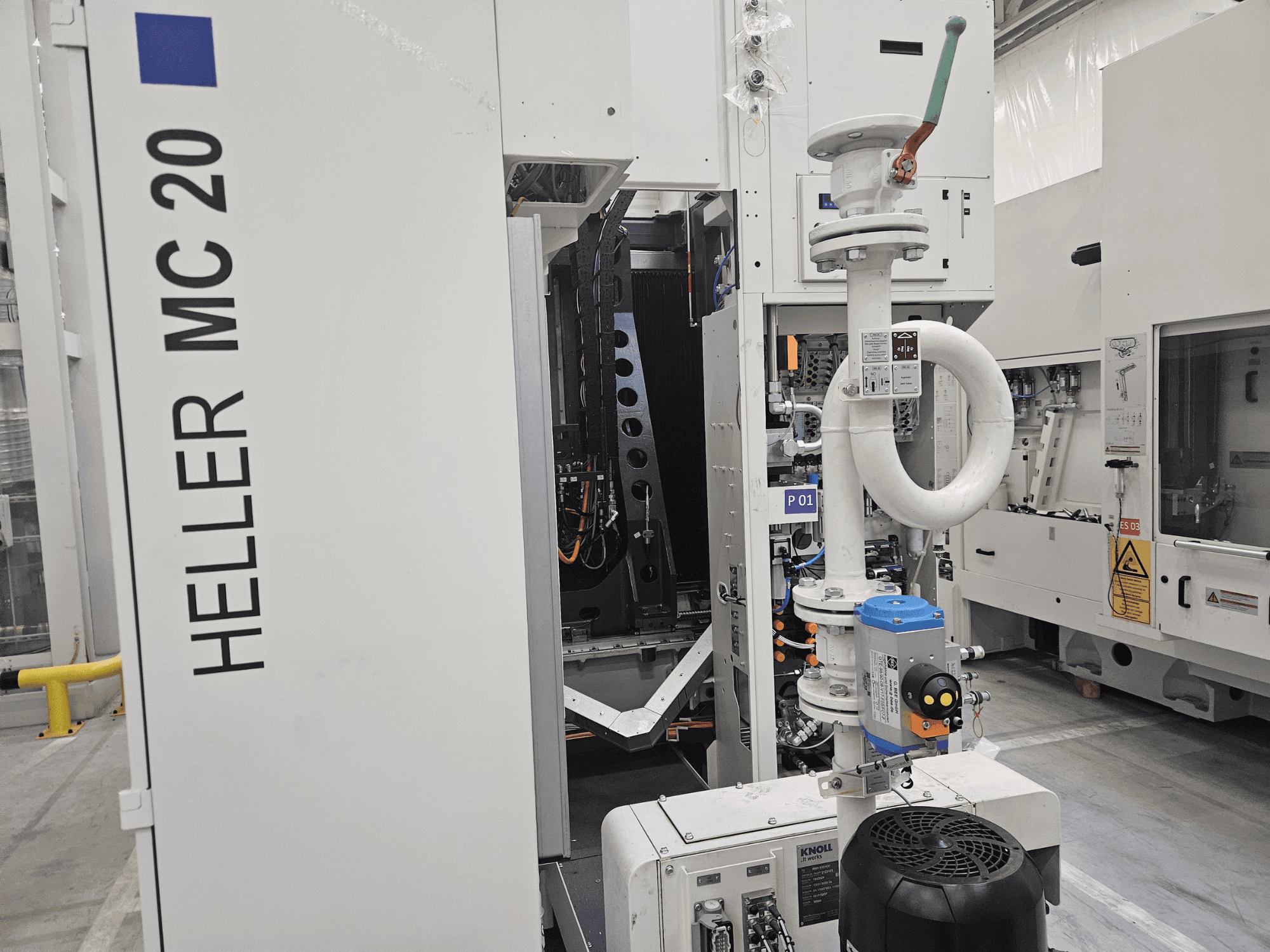 Heller MC 20-maskin i fabriksmiljö, med kontrollpanel och mekaniska komponenter från sidan.