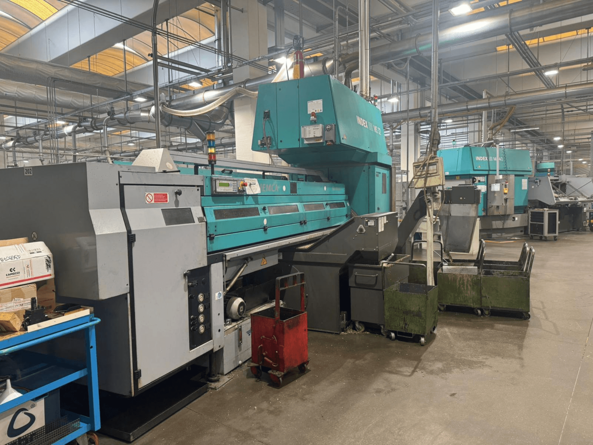 Flerspindlig svarvmaskin, INDEX MS32C, framifrån med reglage och arbetsområde i verkstadsmiljö.