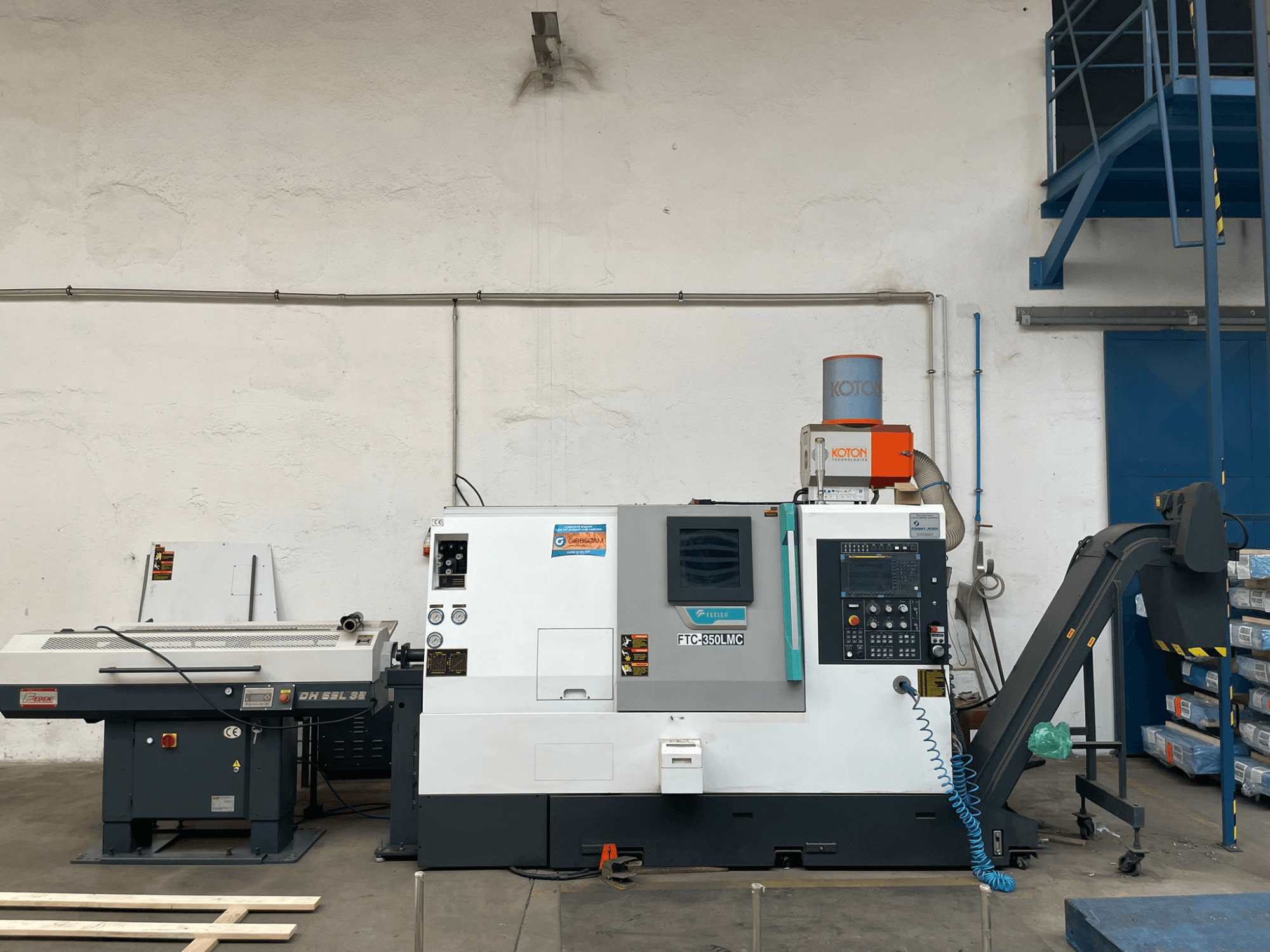 Feeler FTC 350 LMC horisontell svarv i en verkstad, med kontrollpanel och verktygsmatningslinjer. Vy från sidan.