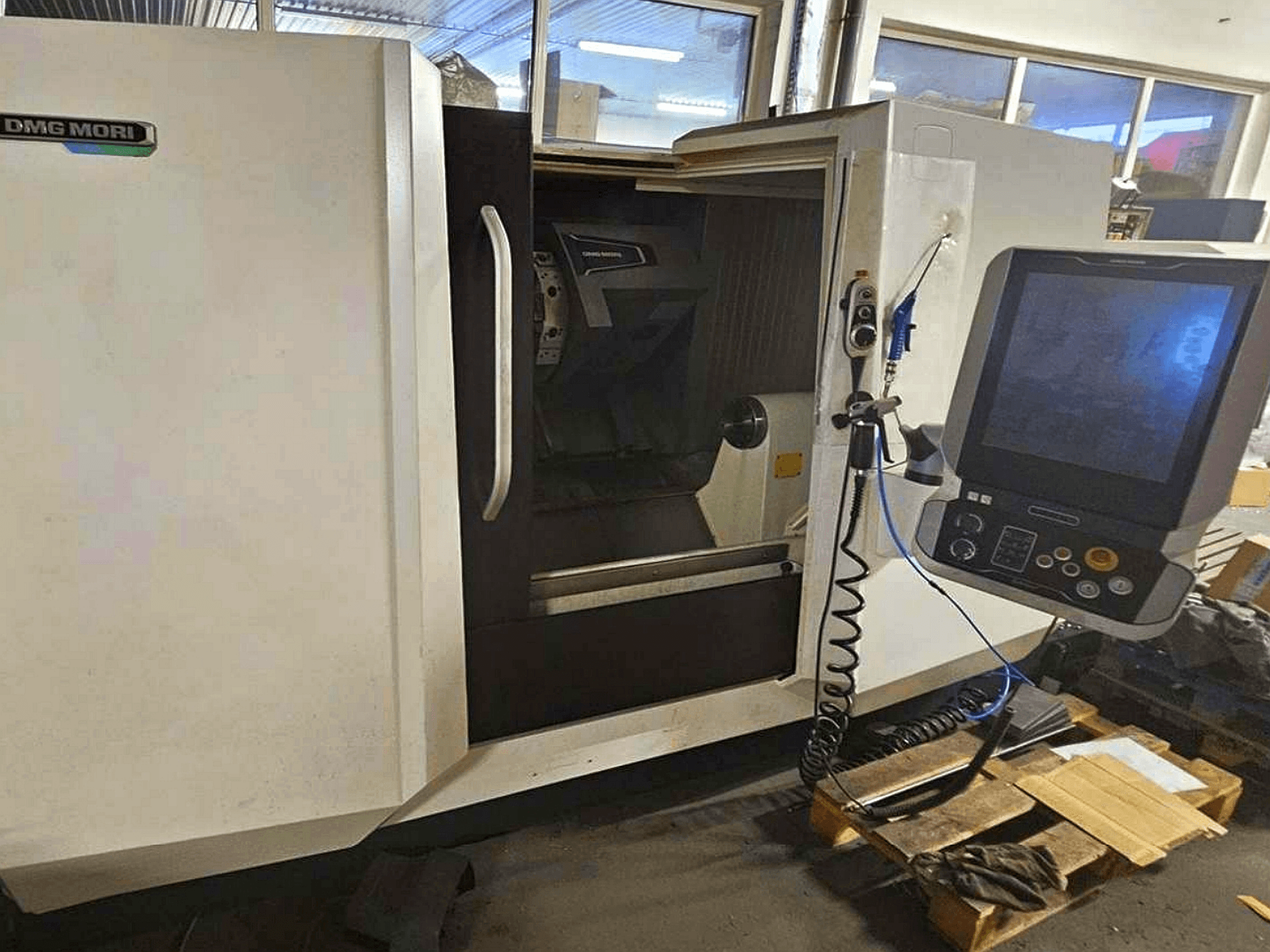 DMG MORI CLX 450 V4 horisontell svarv, framifrån med kontrollpanel, som visar arbetsytan och karossens design.