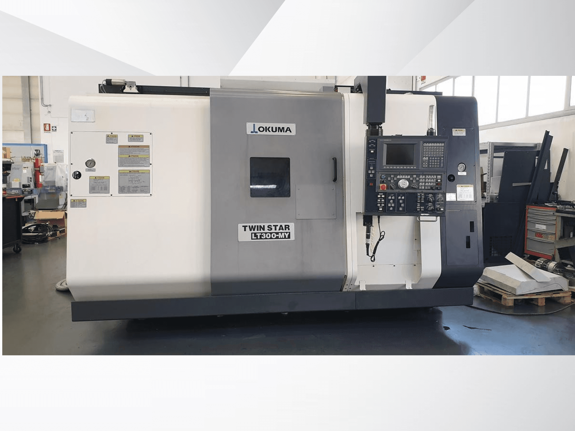 Okuma Twin Star LT300-MY CNC-svarv, framifrån med kontrollpanel och driftsetiketter synliga.