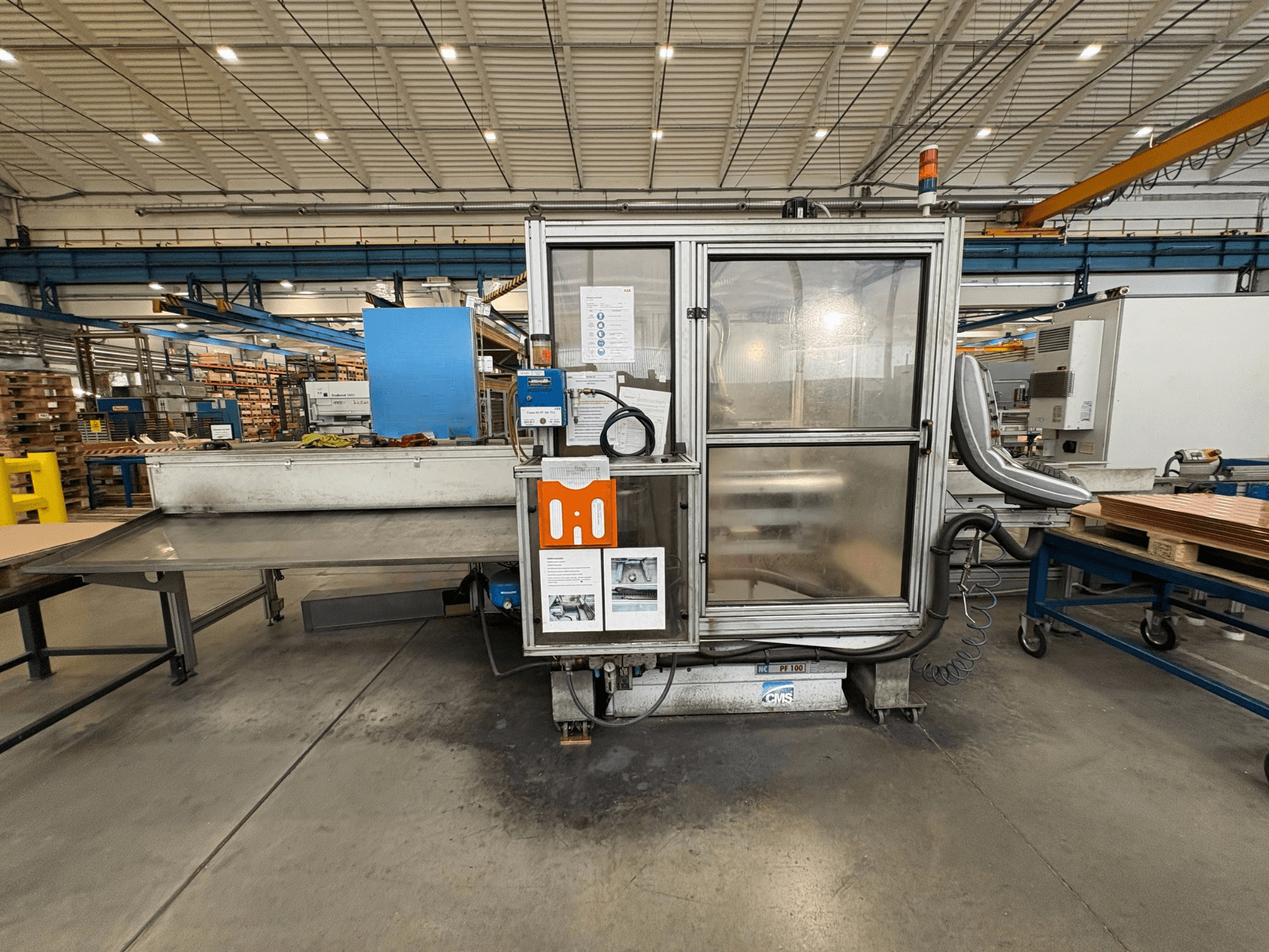CNC-bearbetningscenter för trä CMS NC PF 100, vy framifrån; har kontrollpanel, säkerhetsskåp och arbetsbord.