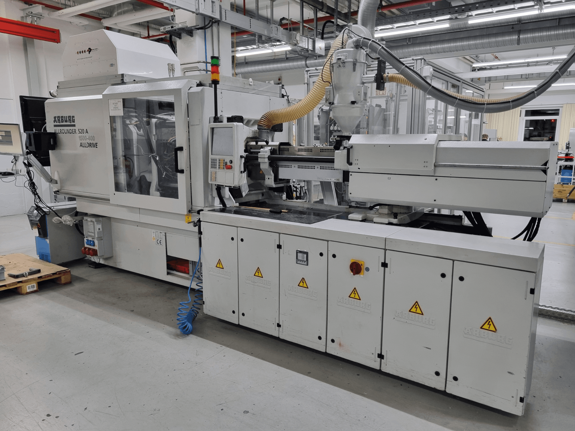 Arburg Allrounder 520 A formsprutningsmaskin, sidovy, visar kontrollpanelen och säkerhetsfunktionerna.