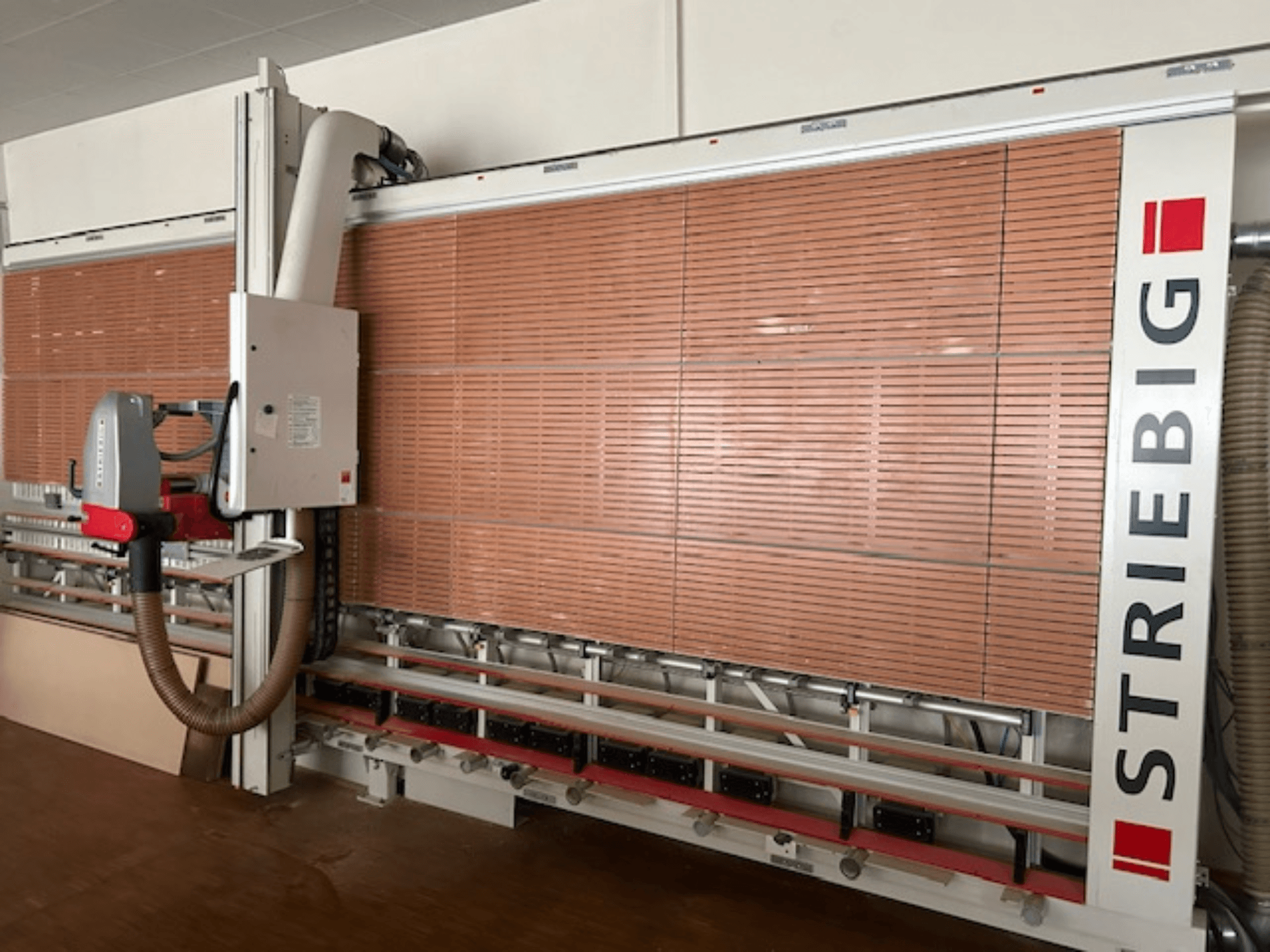 Striebig vertikal panelsåg i sidovy, med motoriserat huvud, kapblad för träpaneler och dammutsugningssystem.